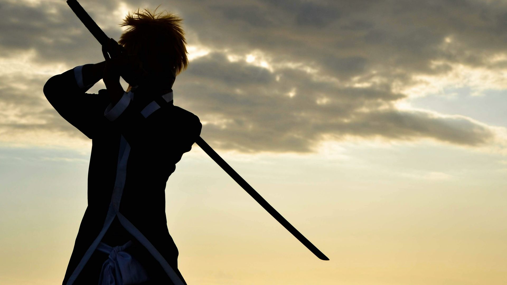 a person with a sword standing in front of a body of water