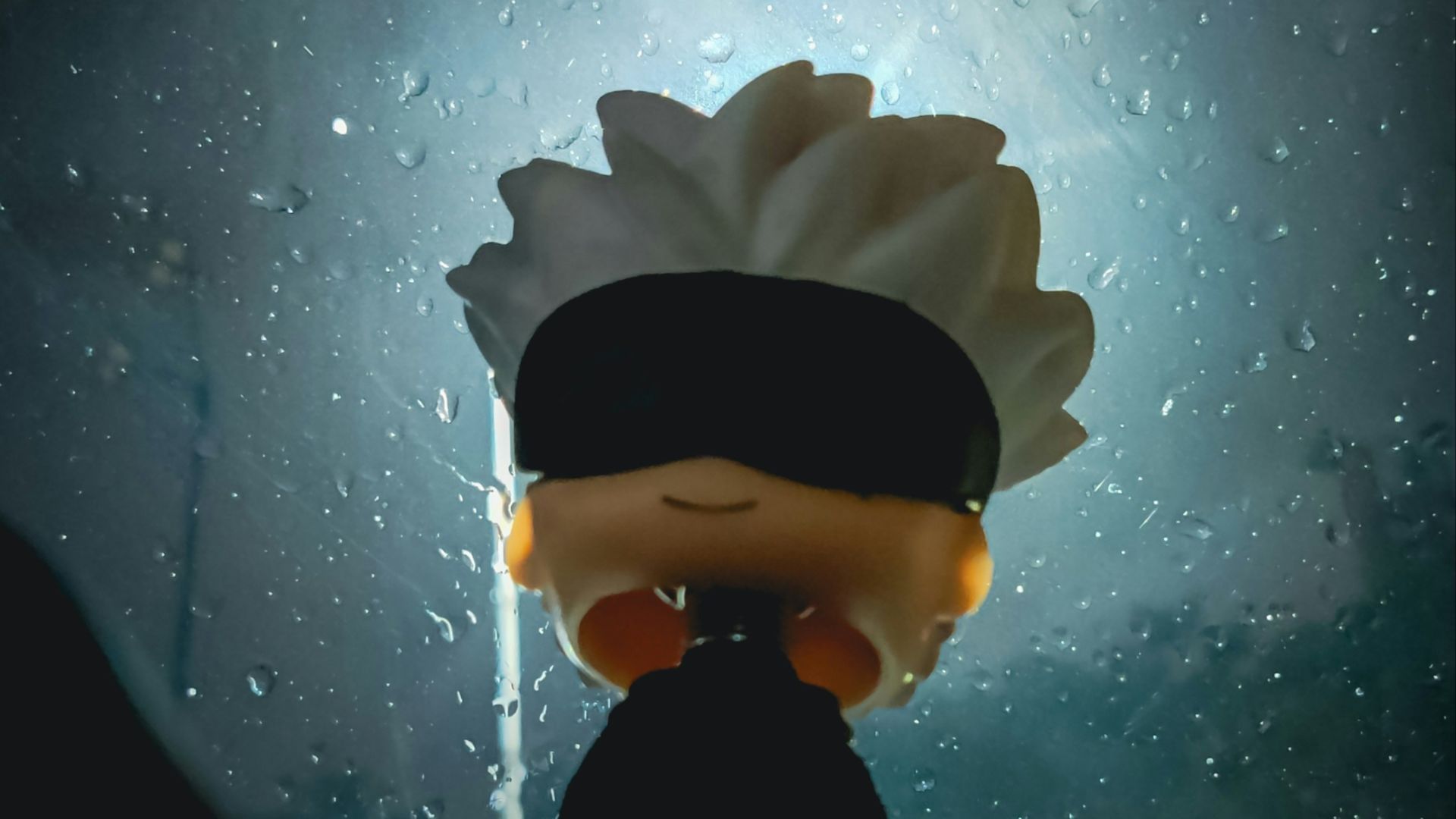 A person with a blindfolded head standing in front of a window