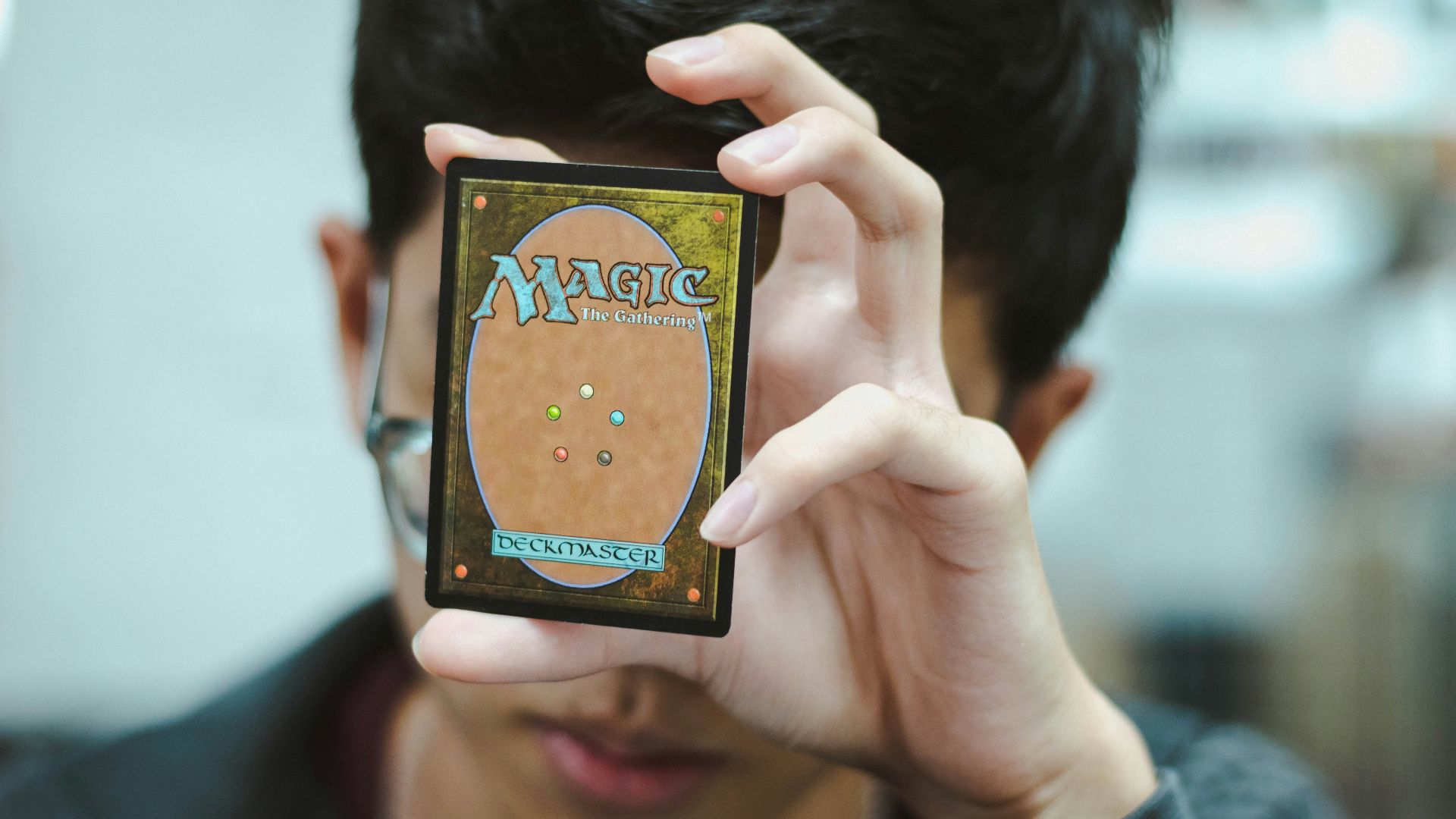 boy holding Magic: The Gathering trading card