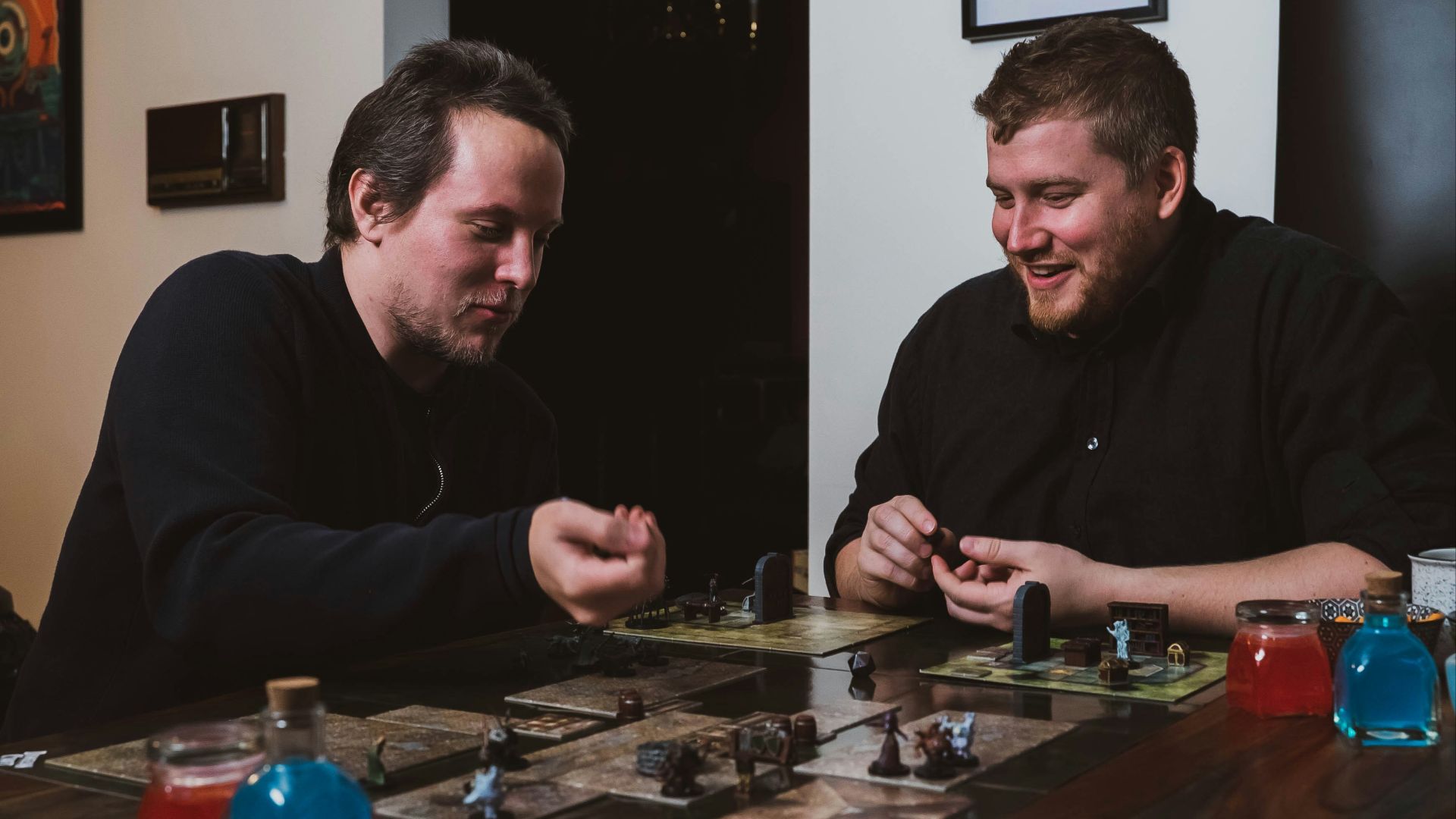 two men sitting at a table playing a board game