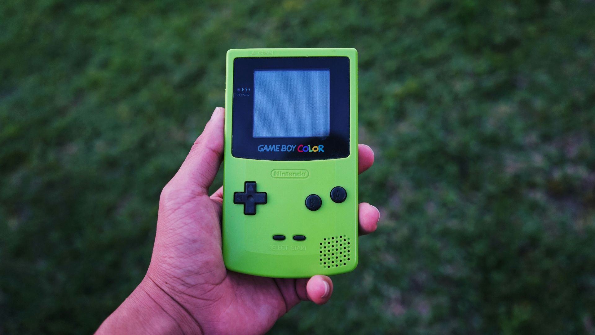 person holding a green Gameboy color console