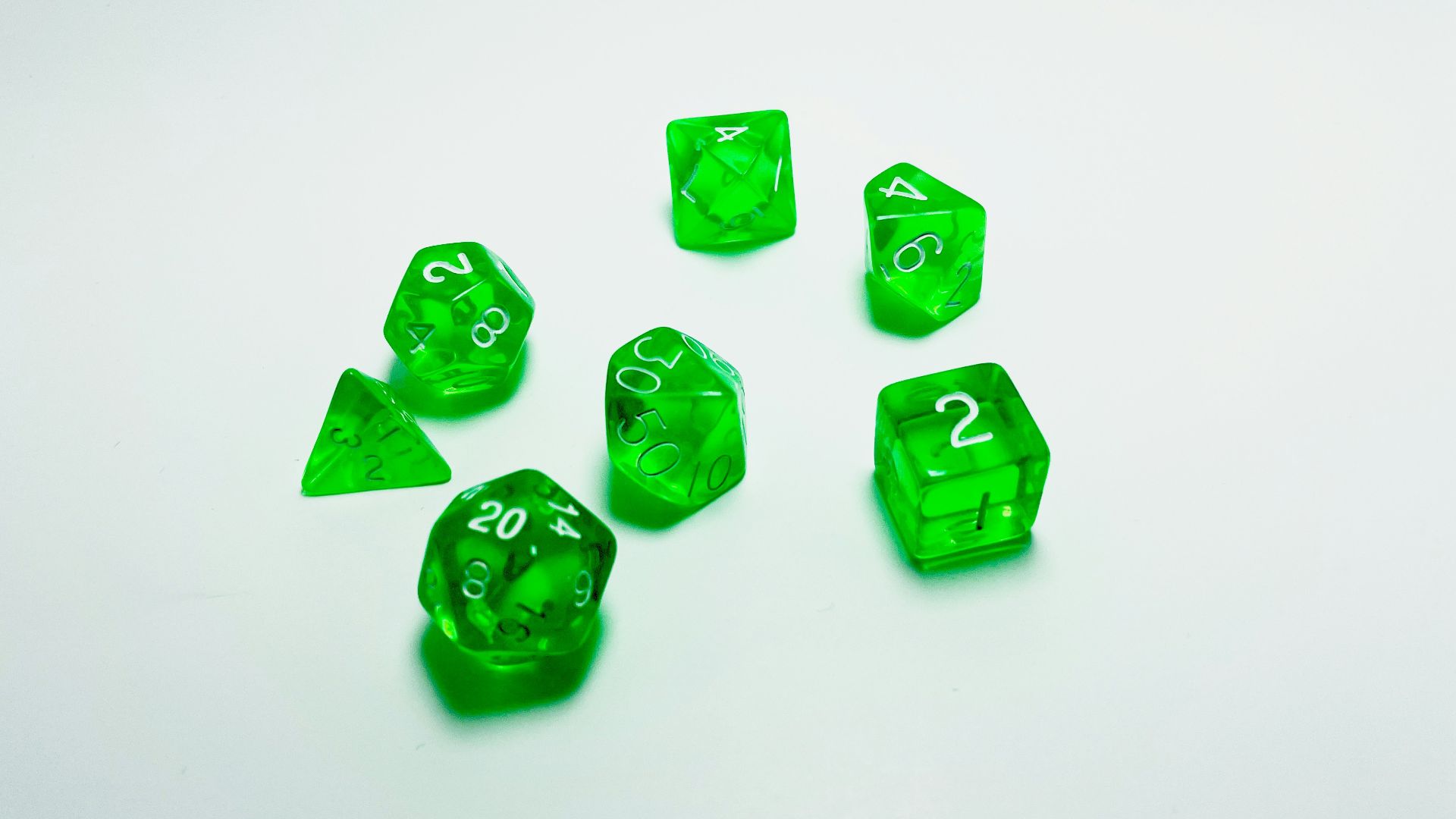 green plastic dice on white surface