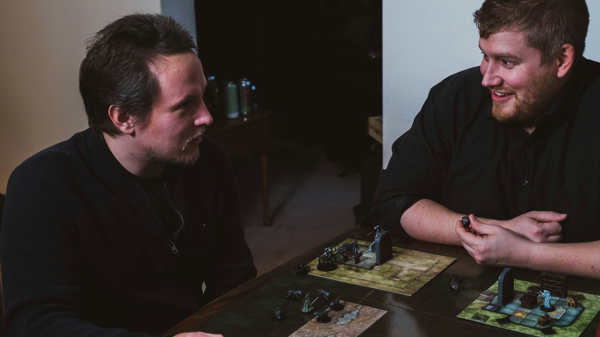 two men sitting at a table playing a game