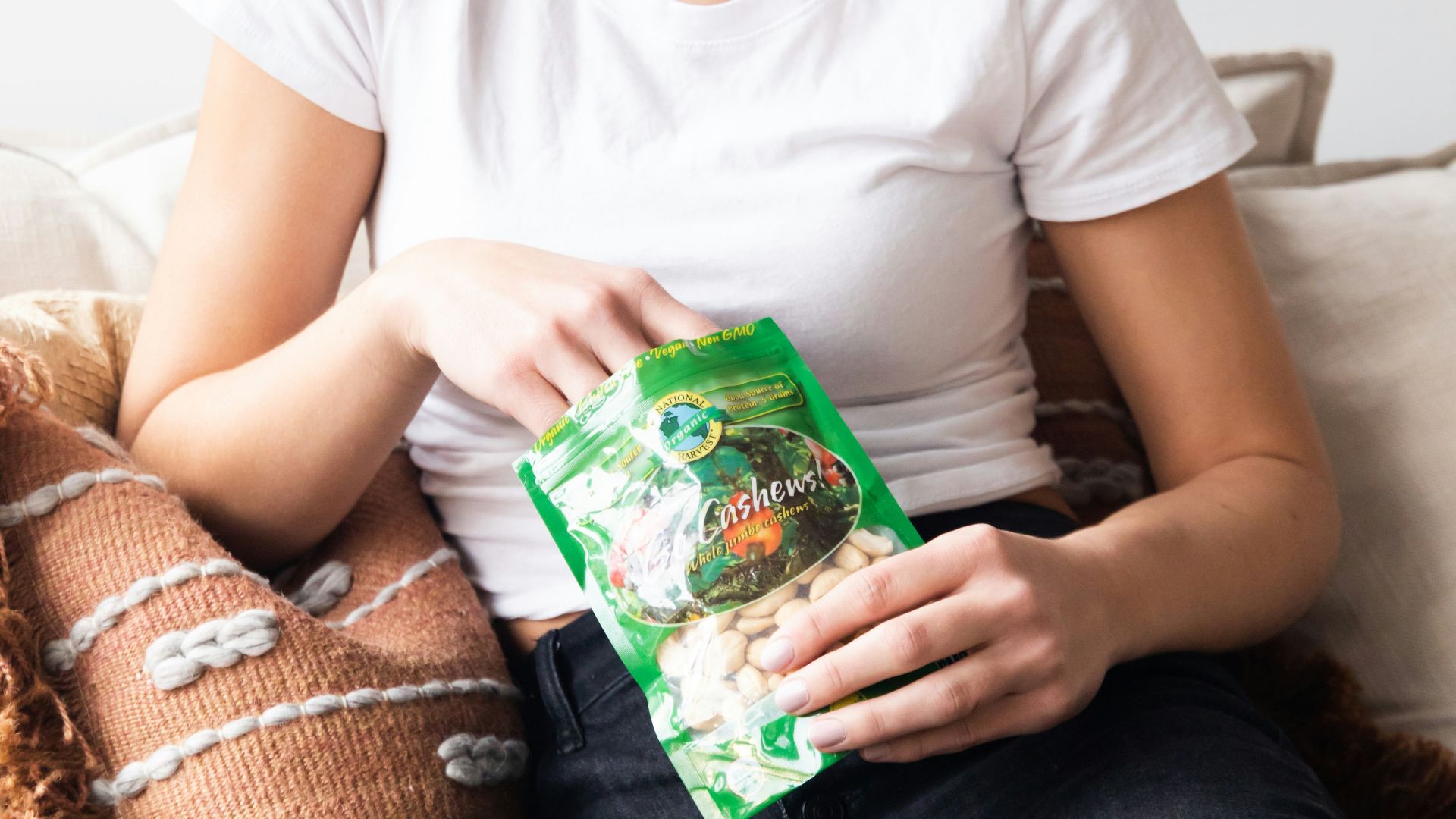 woman in white crew neck t-shirt holding green plastic pack