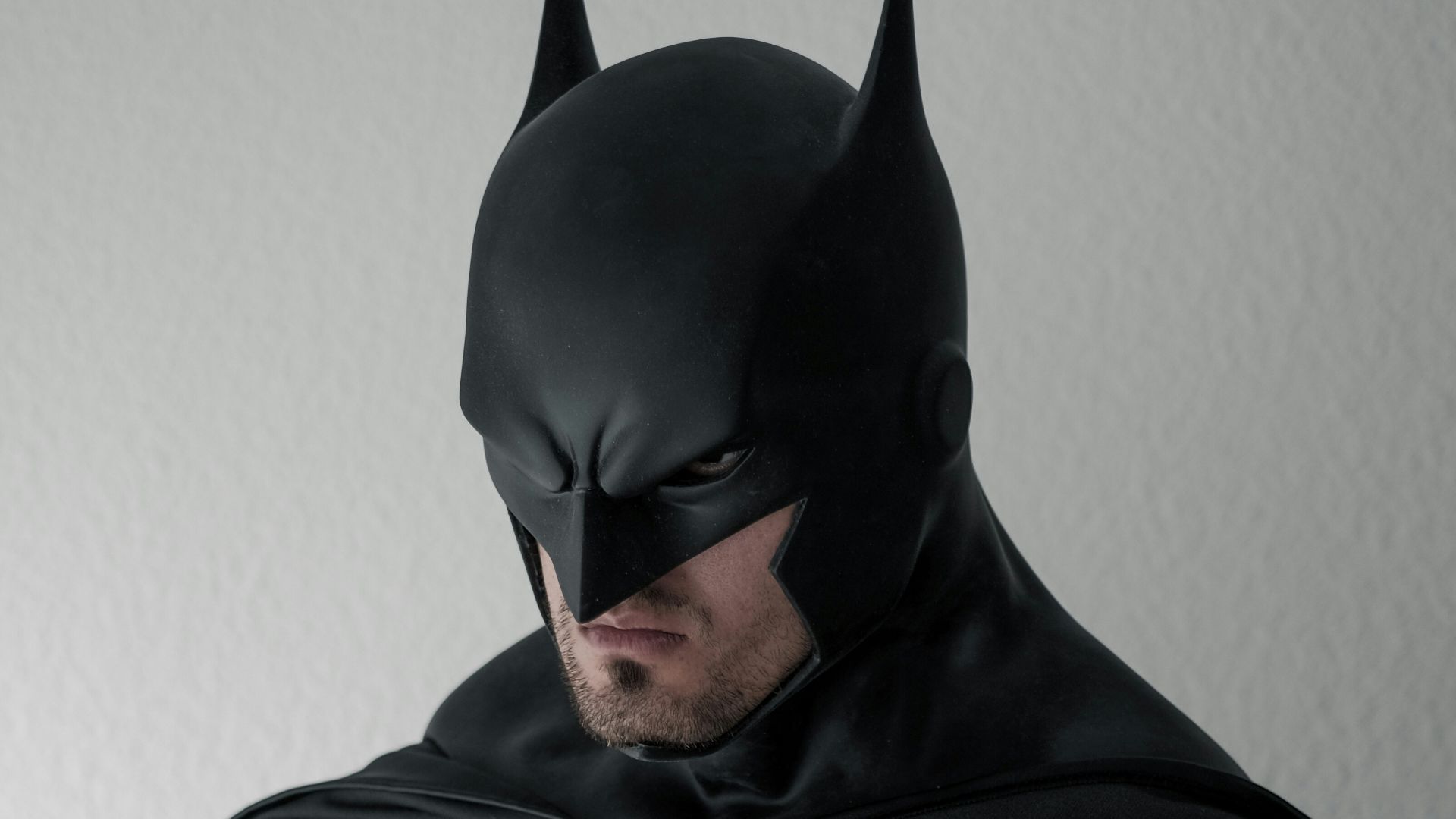 man in black and gray stripe hoodie sitting on brown wooden chair