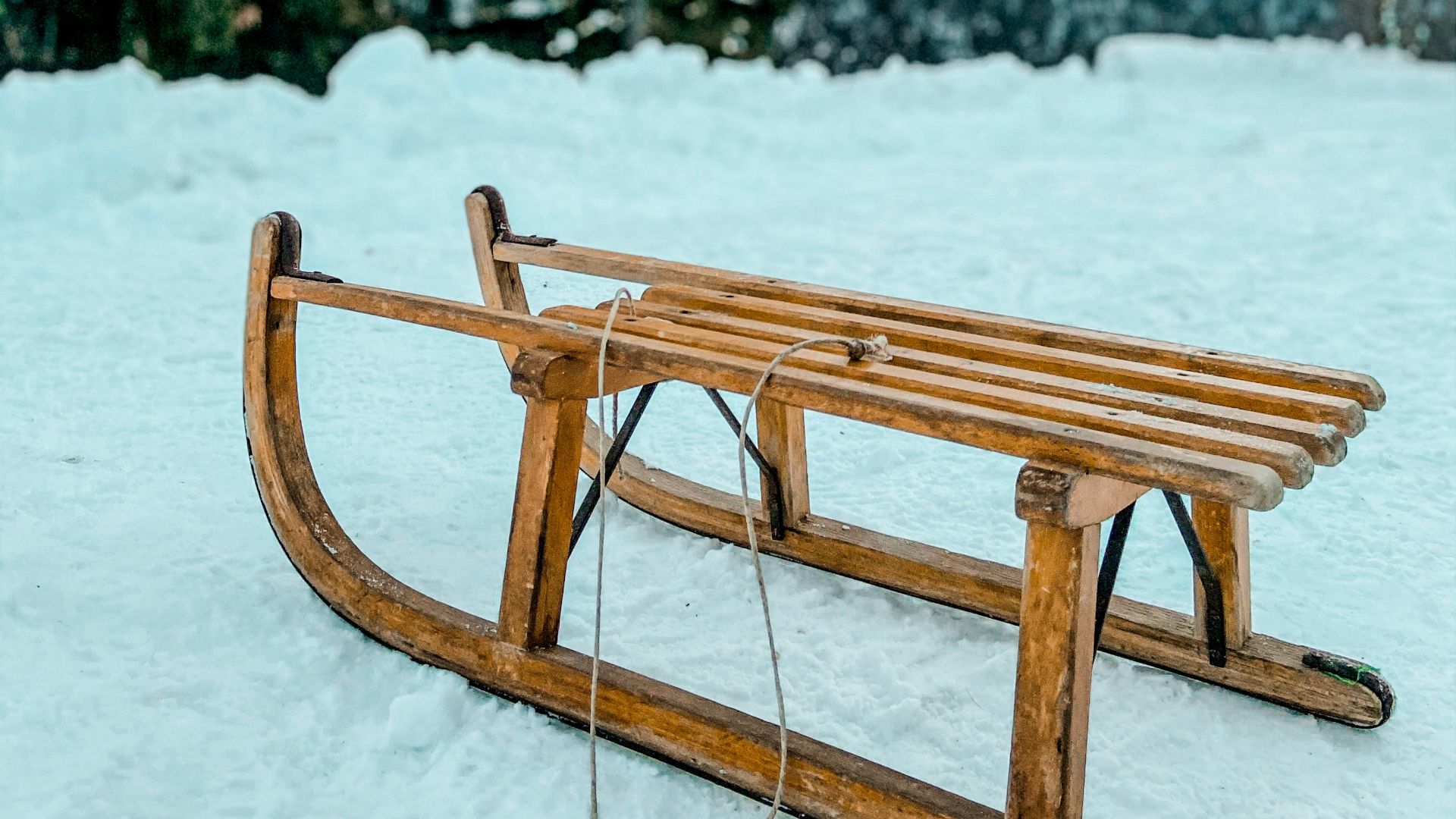 brown wooden picnic table on snow covered ground during daytime