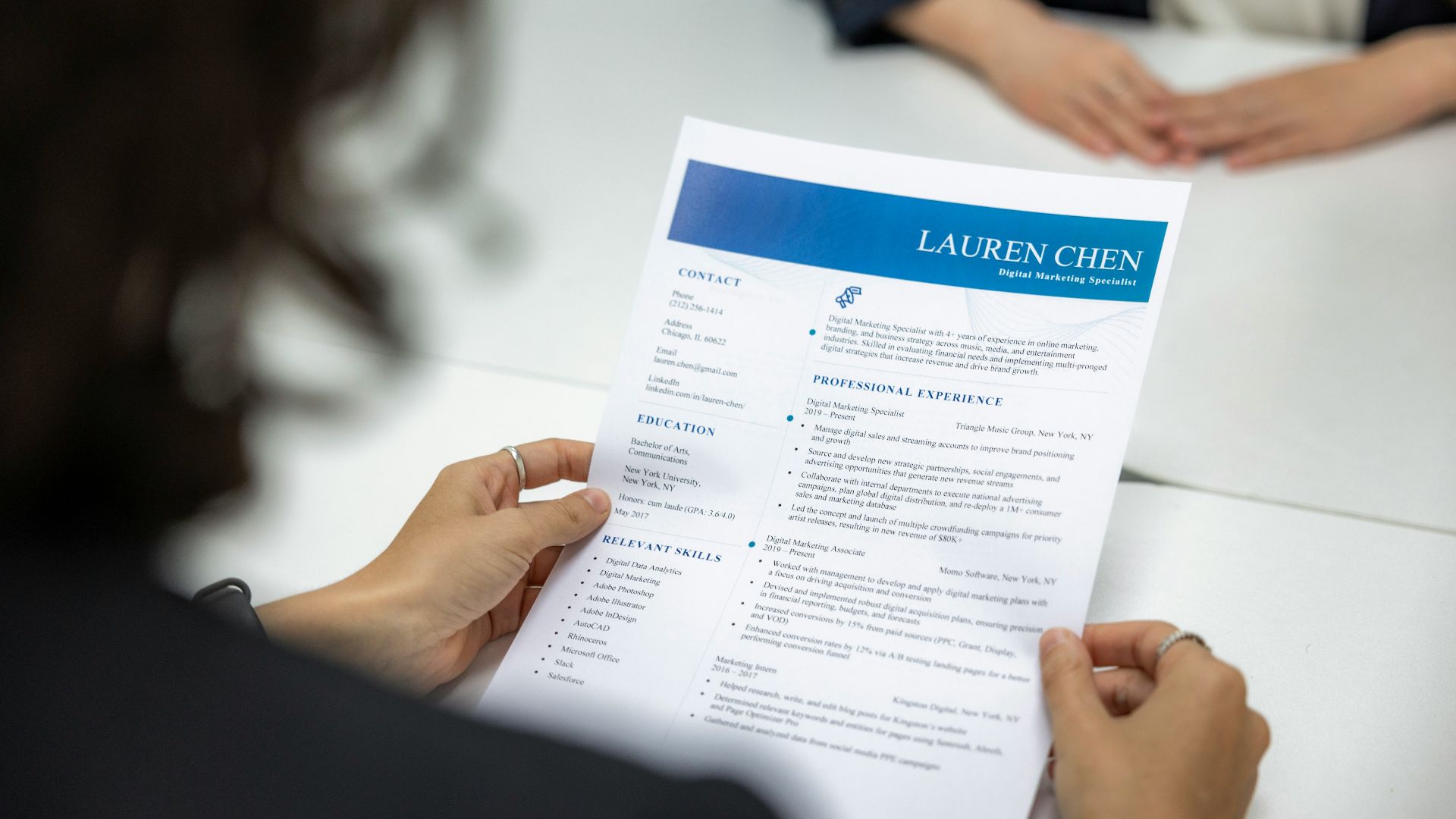 a woman is reading a resume at a table