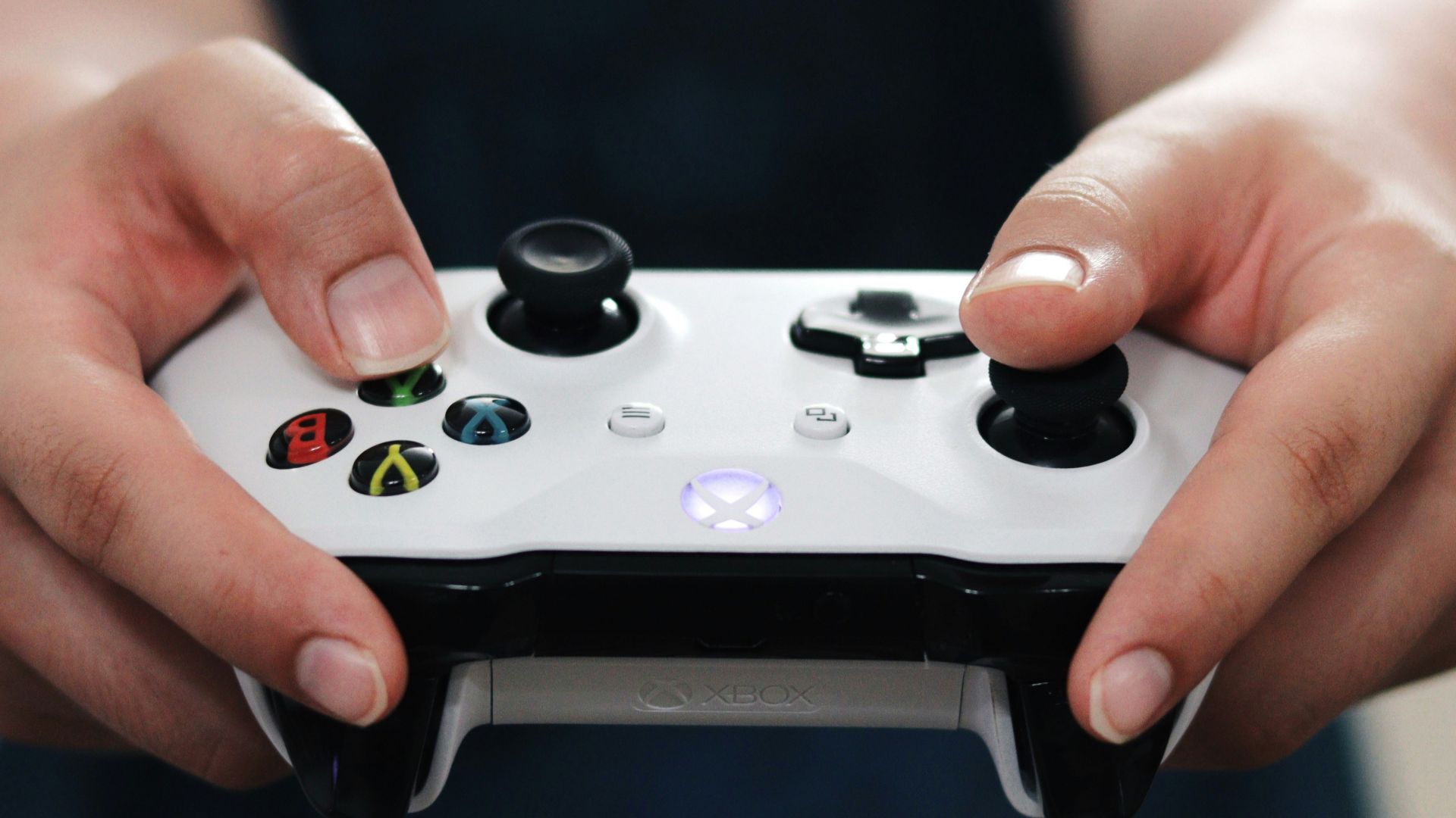 person holding white and black xbox one game controller