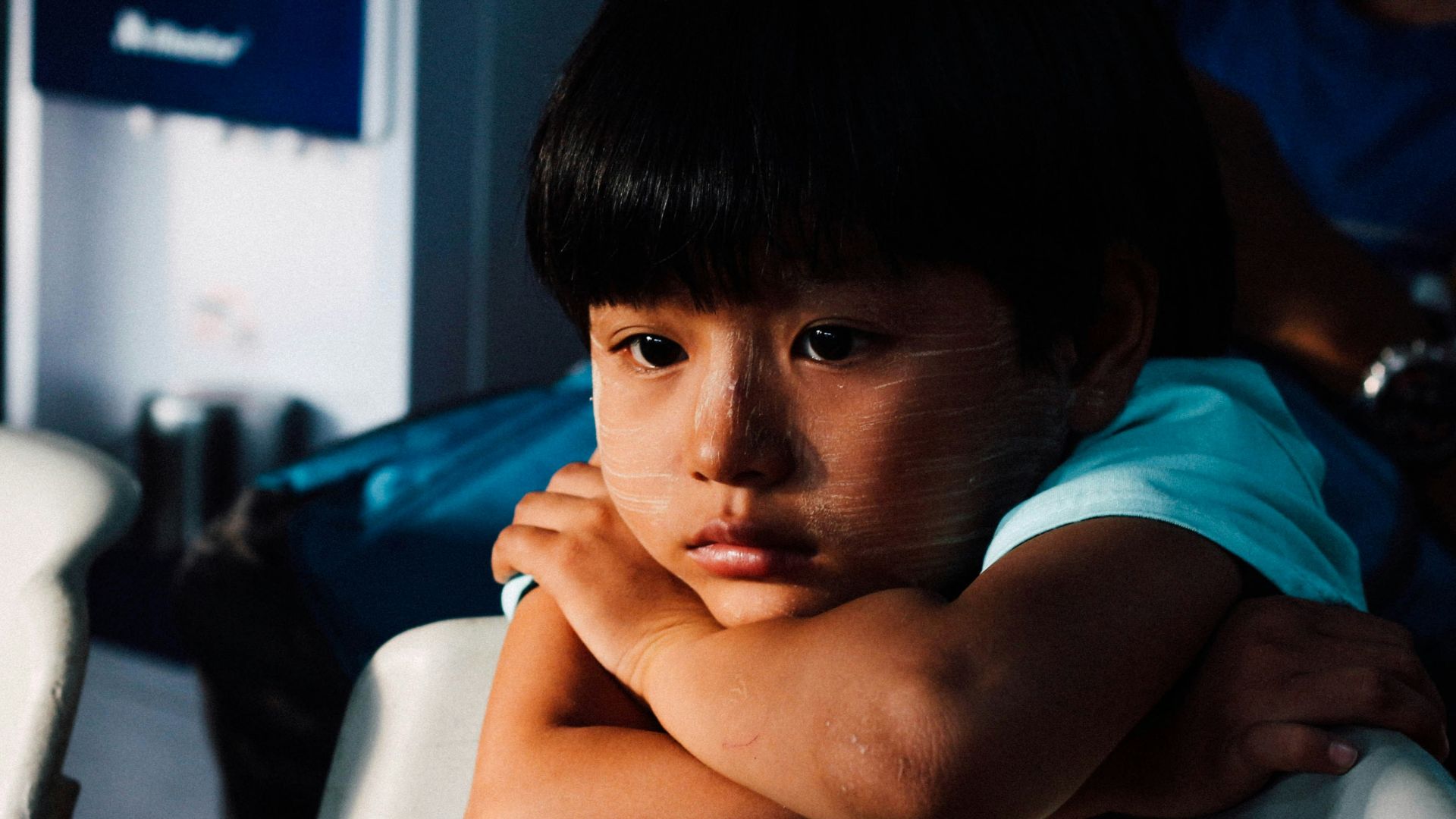 boy leaning on white chair