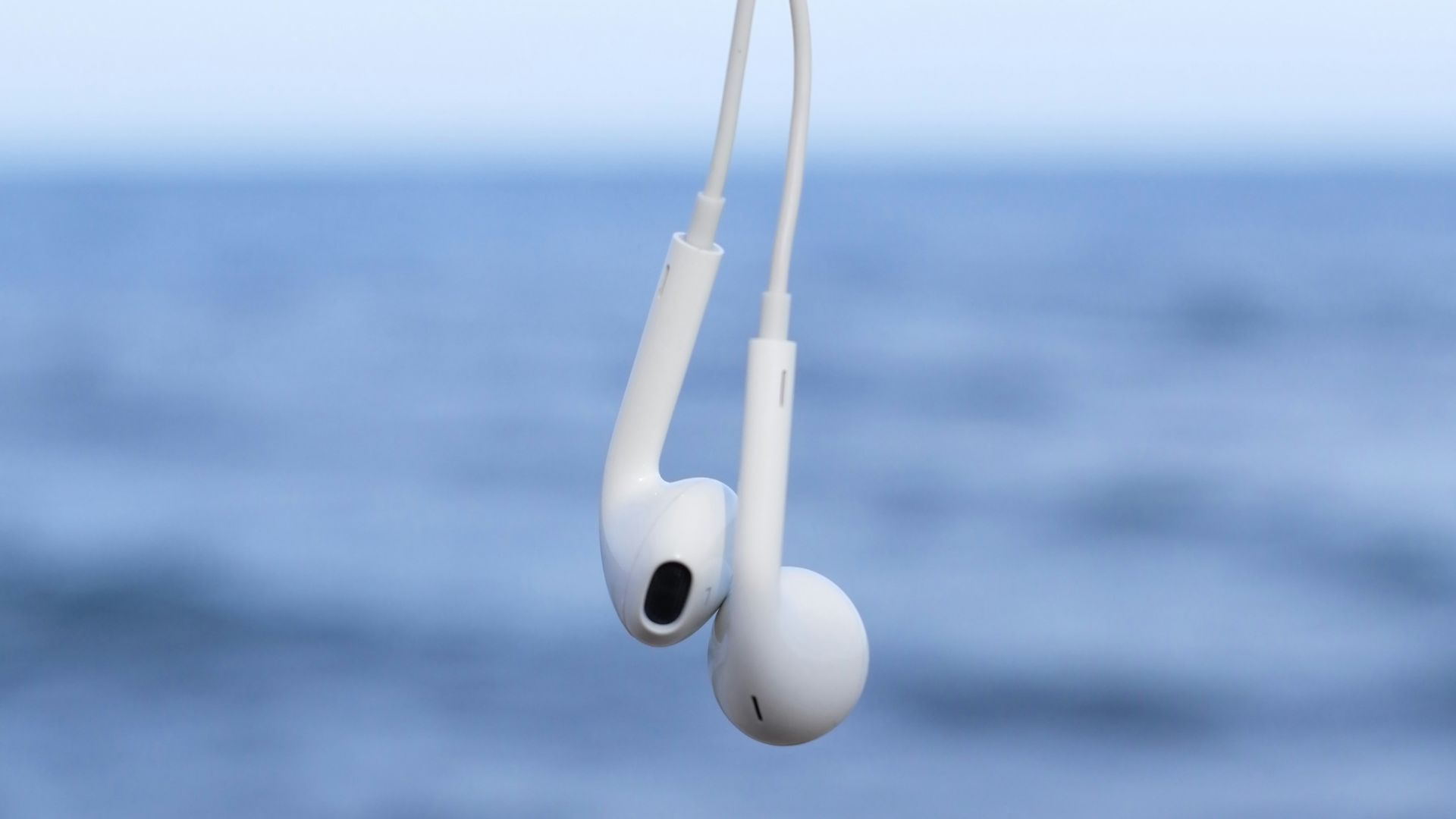 a pair of ear buds hanging from a string