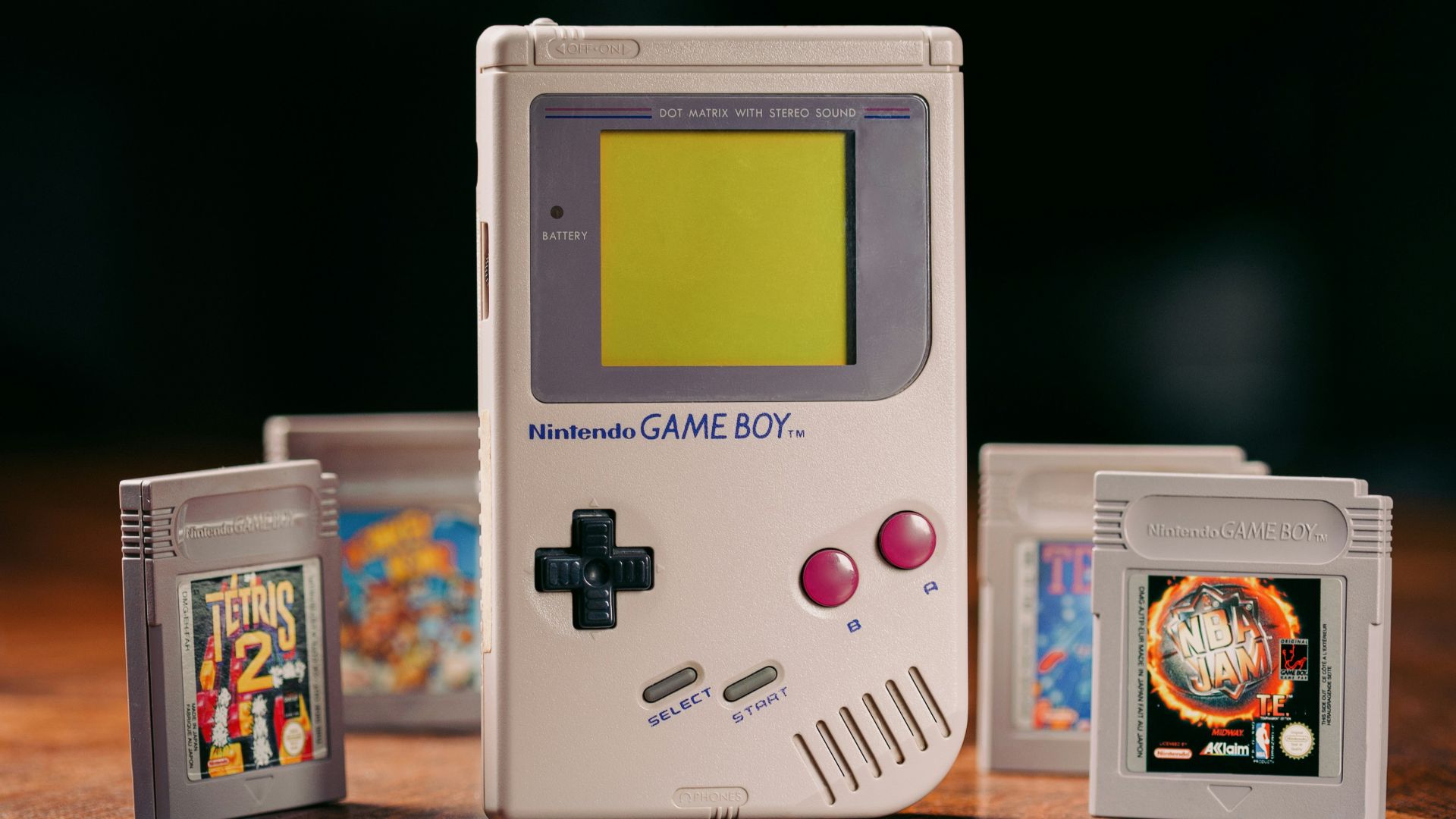 a nintendo game boy sitting on top of a wooden table