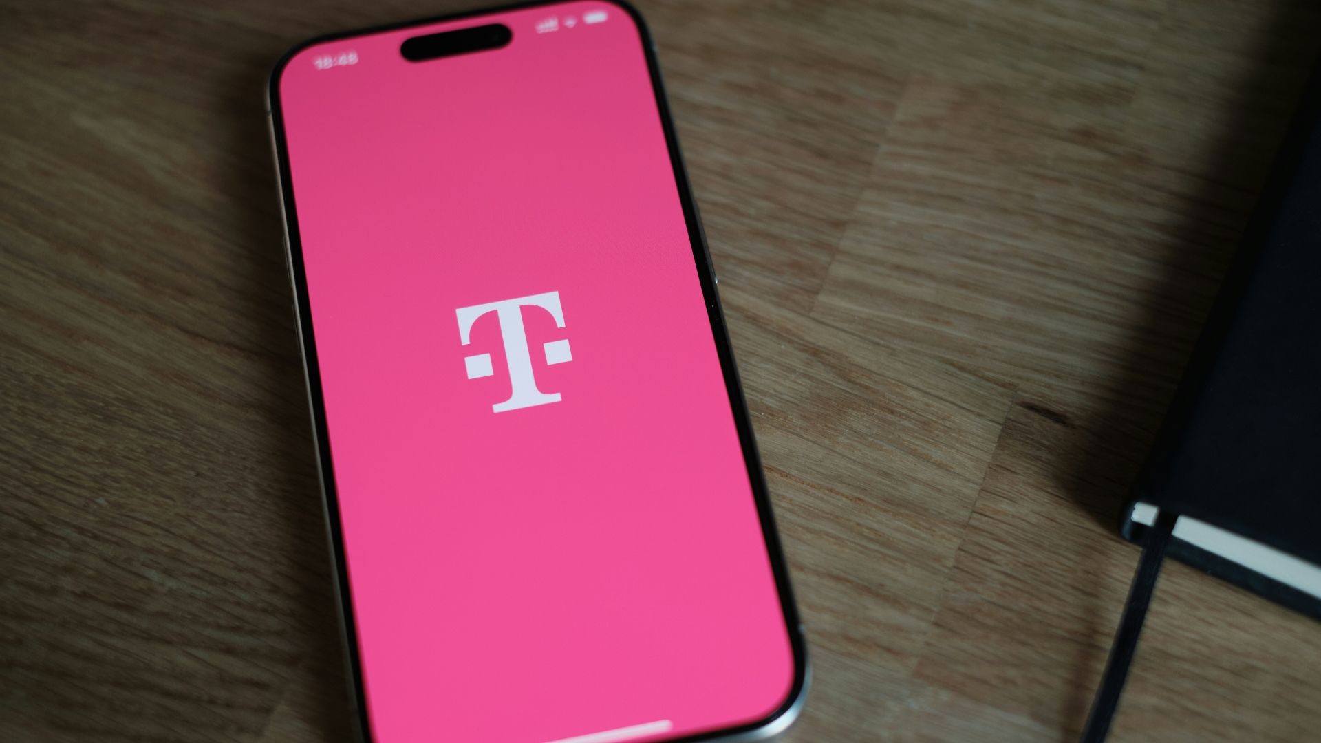 A pink phone sitting on top of a wooden table
