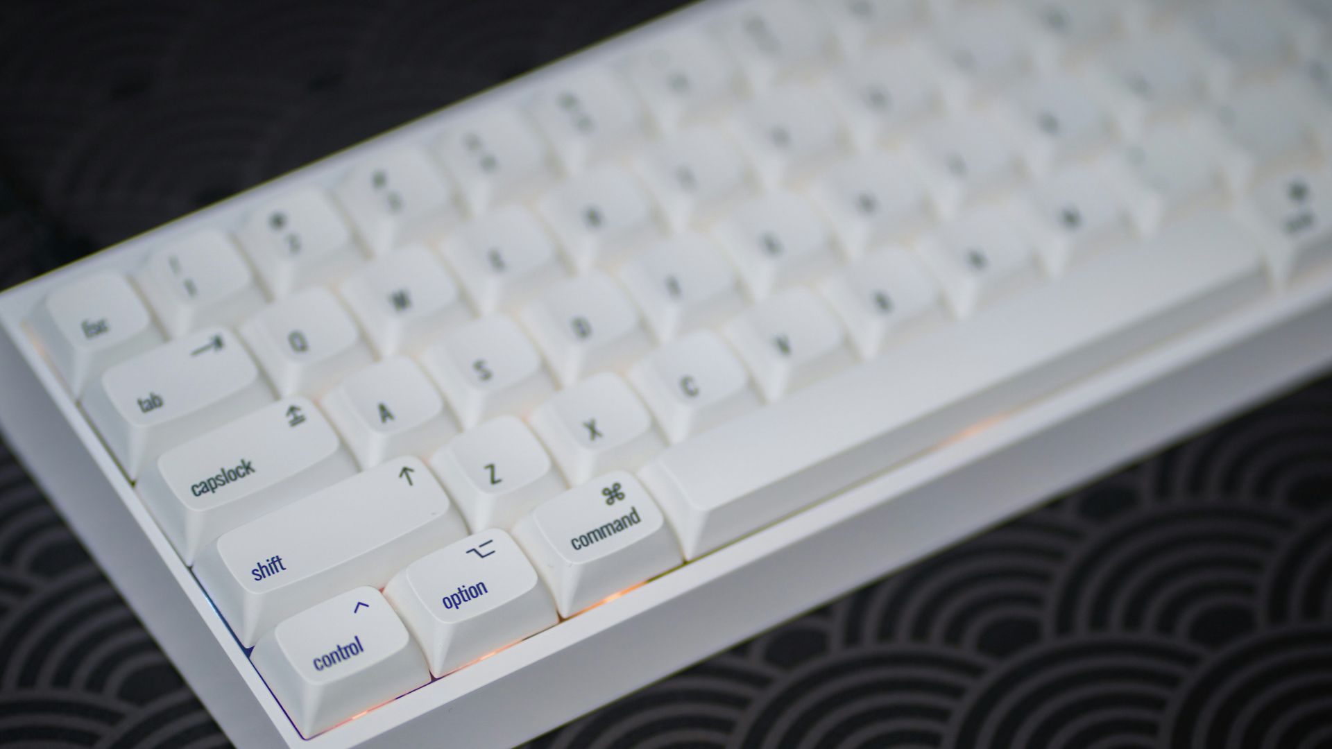 a close up of a white keyboard on a black surface