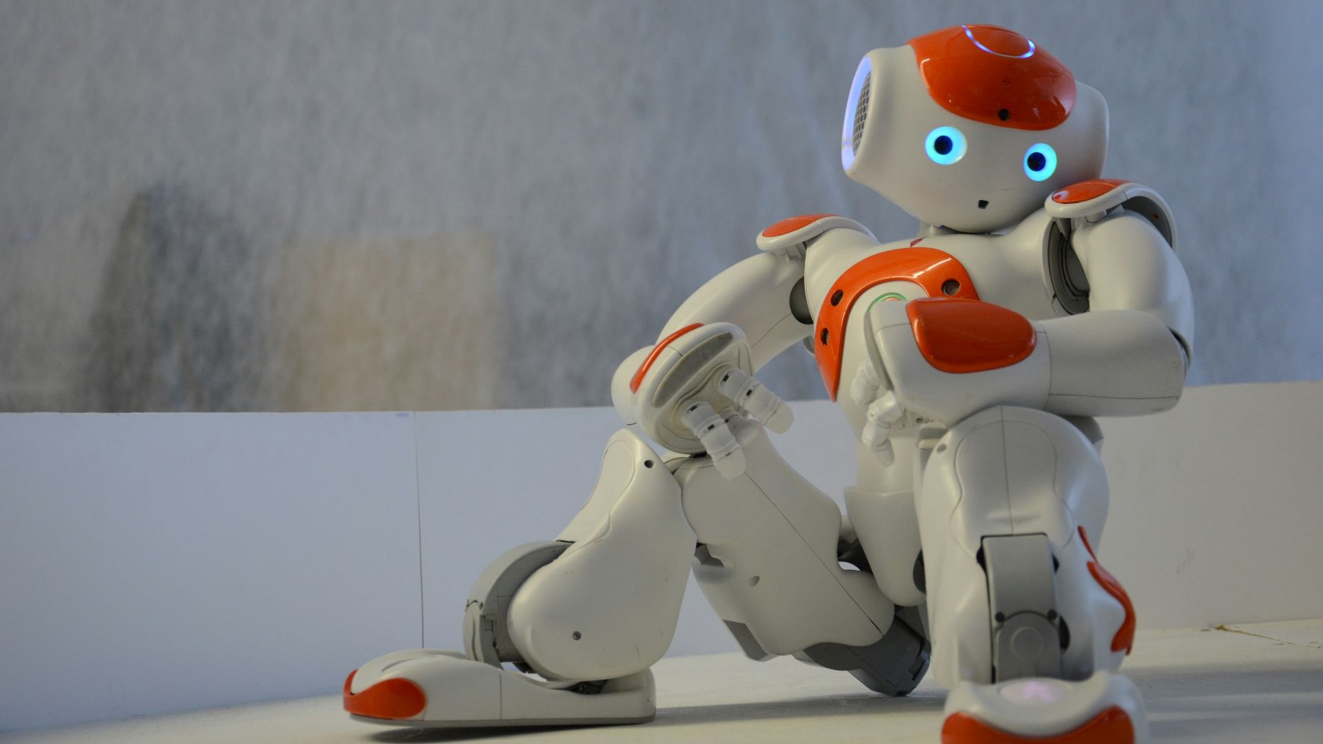 white and orange robot near wall