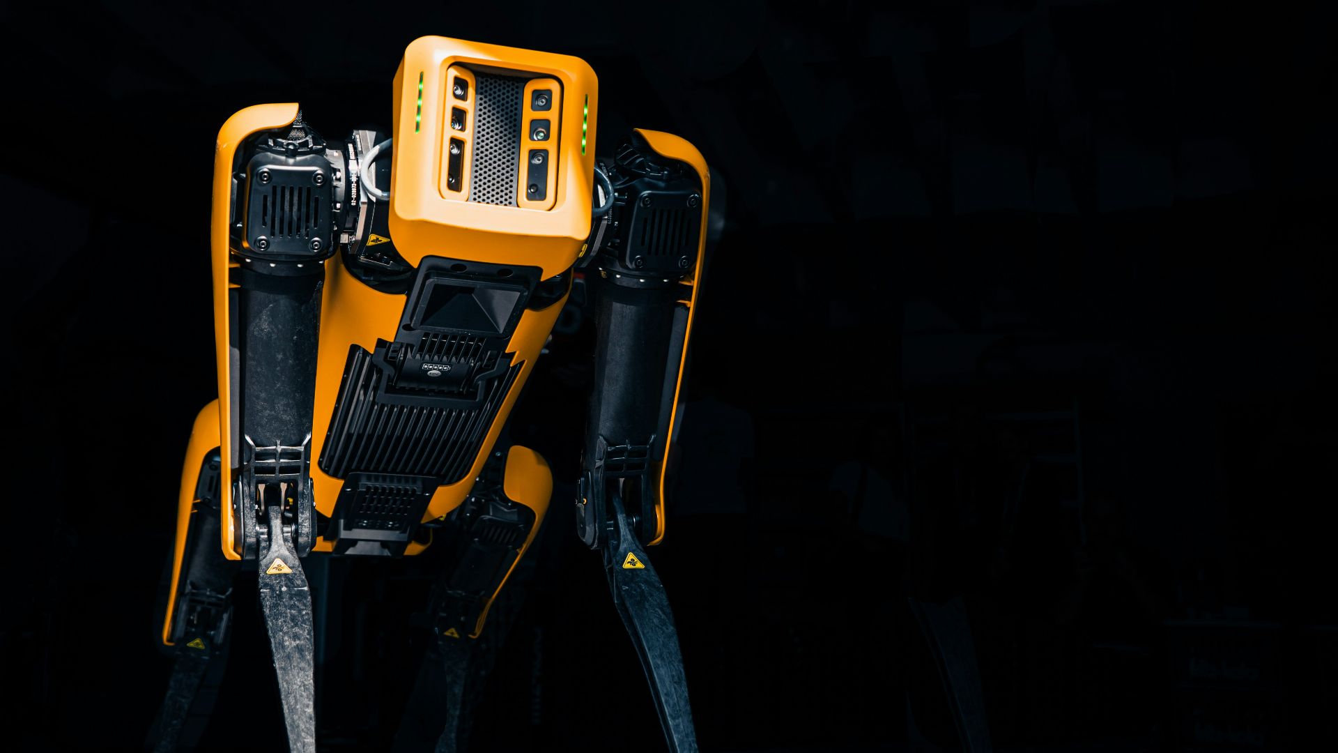 a yellow and black robot standing in the dark