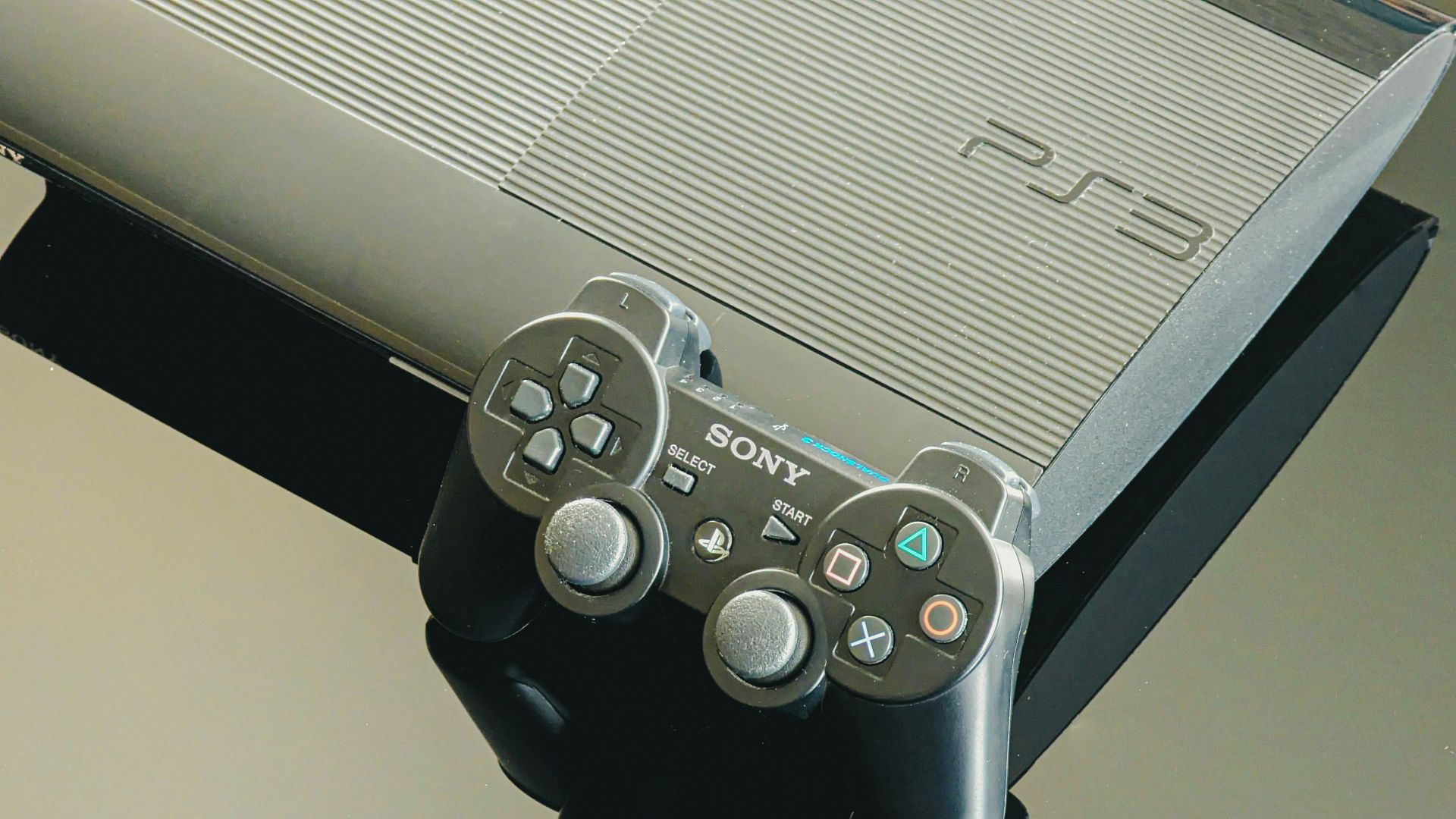 A playstation 3 console and its controller.