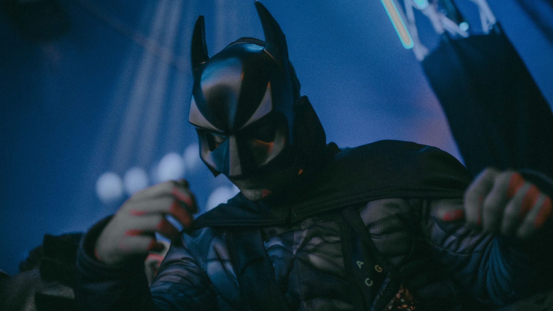 a man in a batman costume holding a cell phone