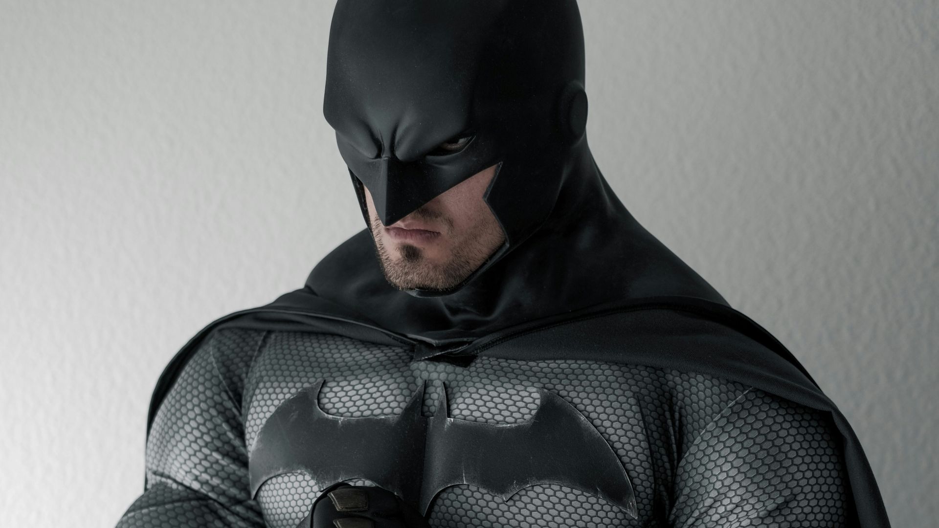 man in black and gray stripe hoodie sitting on brown wooden chair