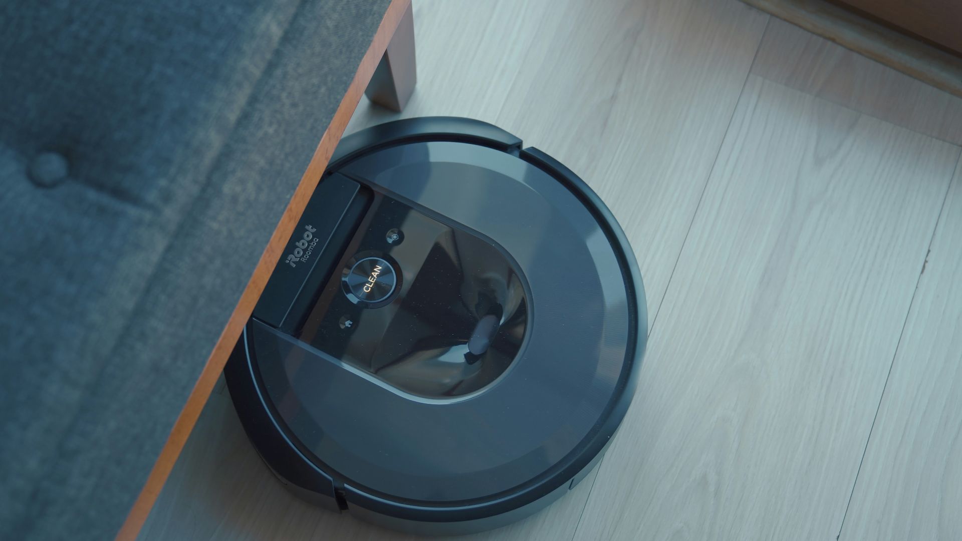 a robotic vacuum is on the floor next to a couch
