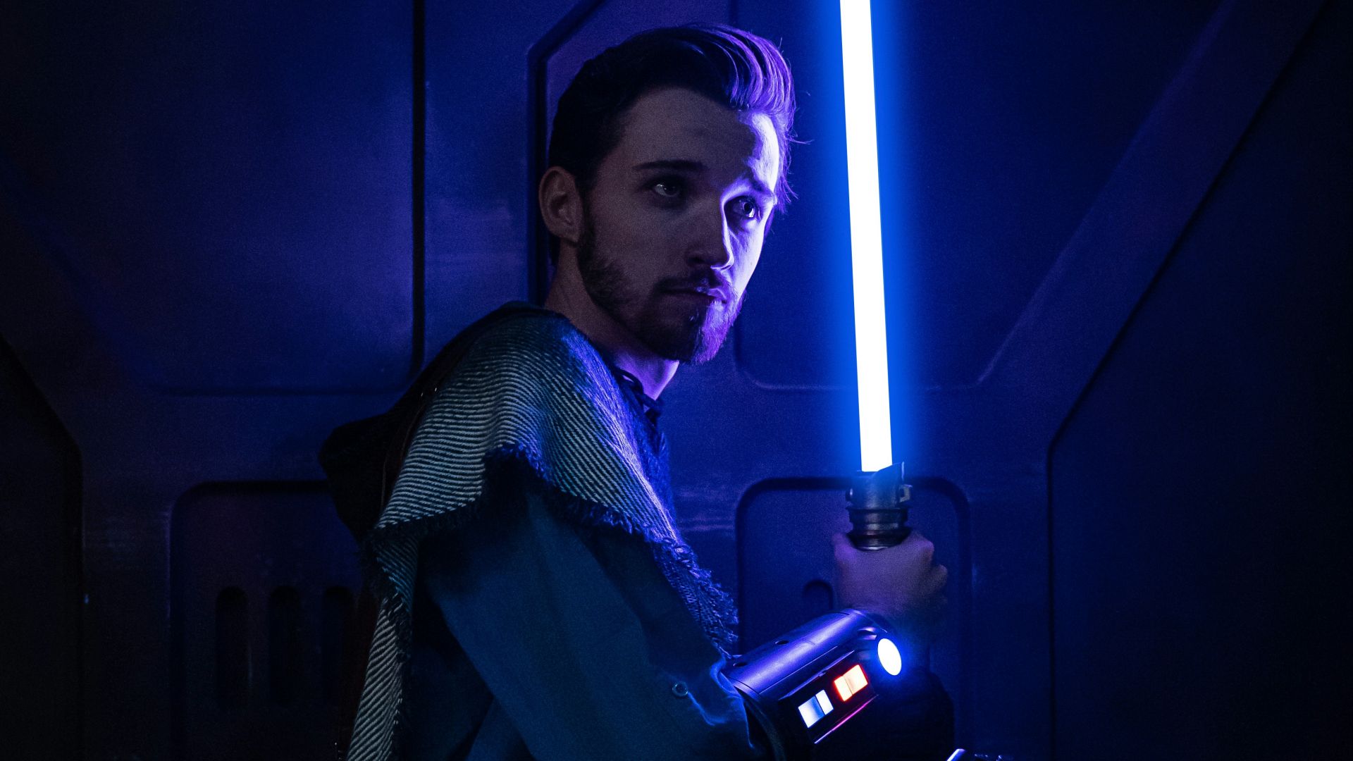 a man holding a light saber in a dark room