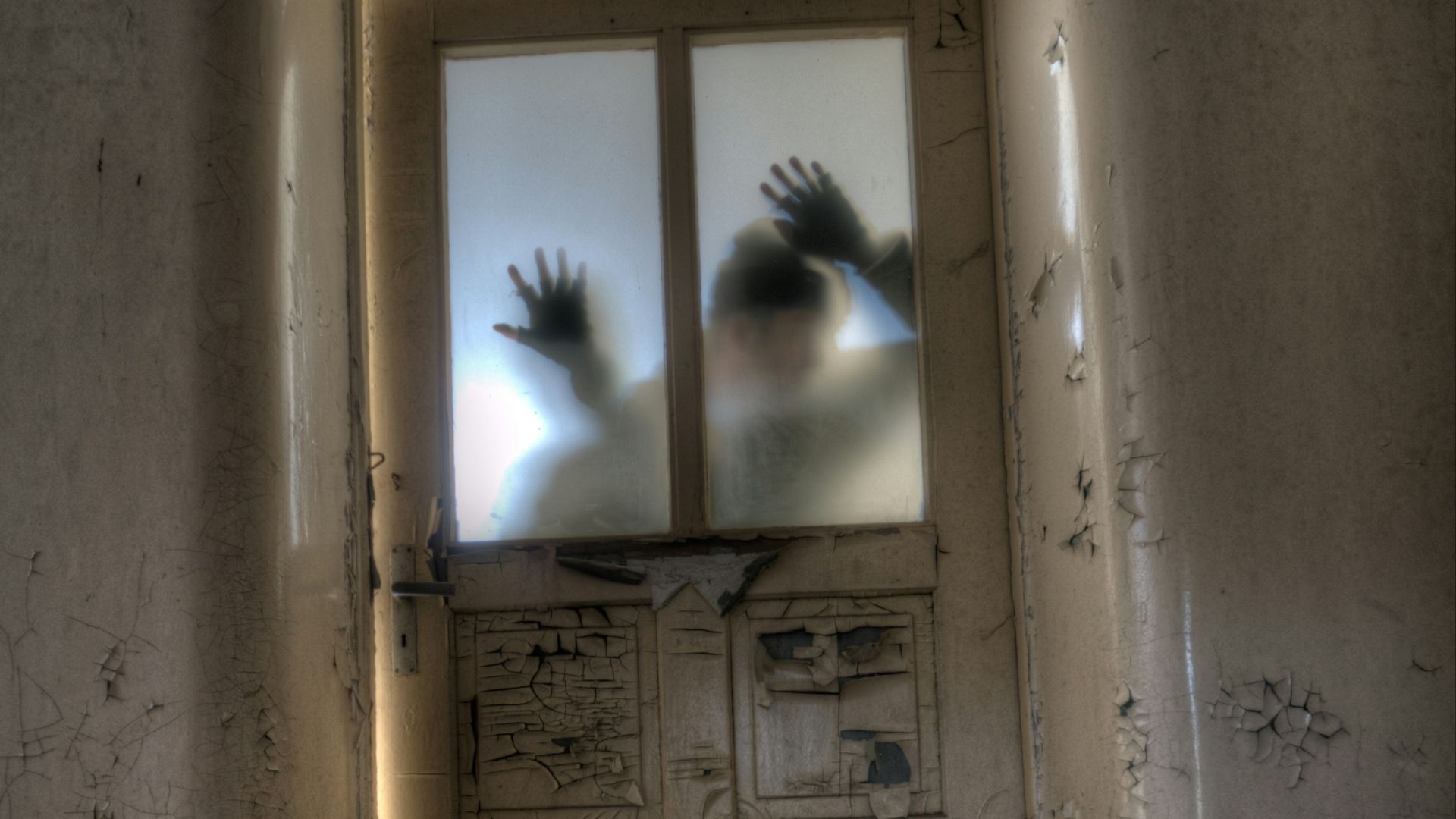 man leaning on frosted glass panel door