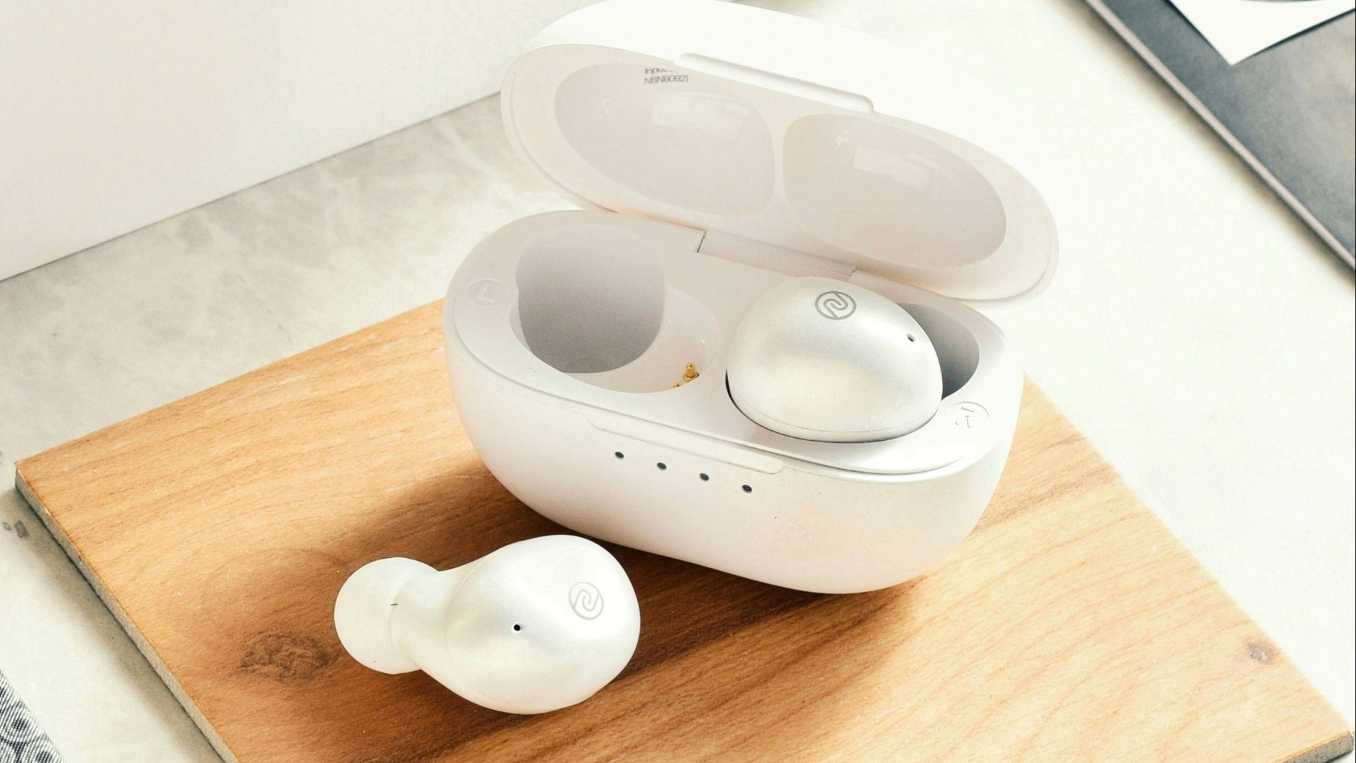 a pair of ear buds sitting on a wooden tray