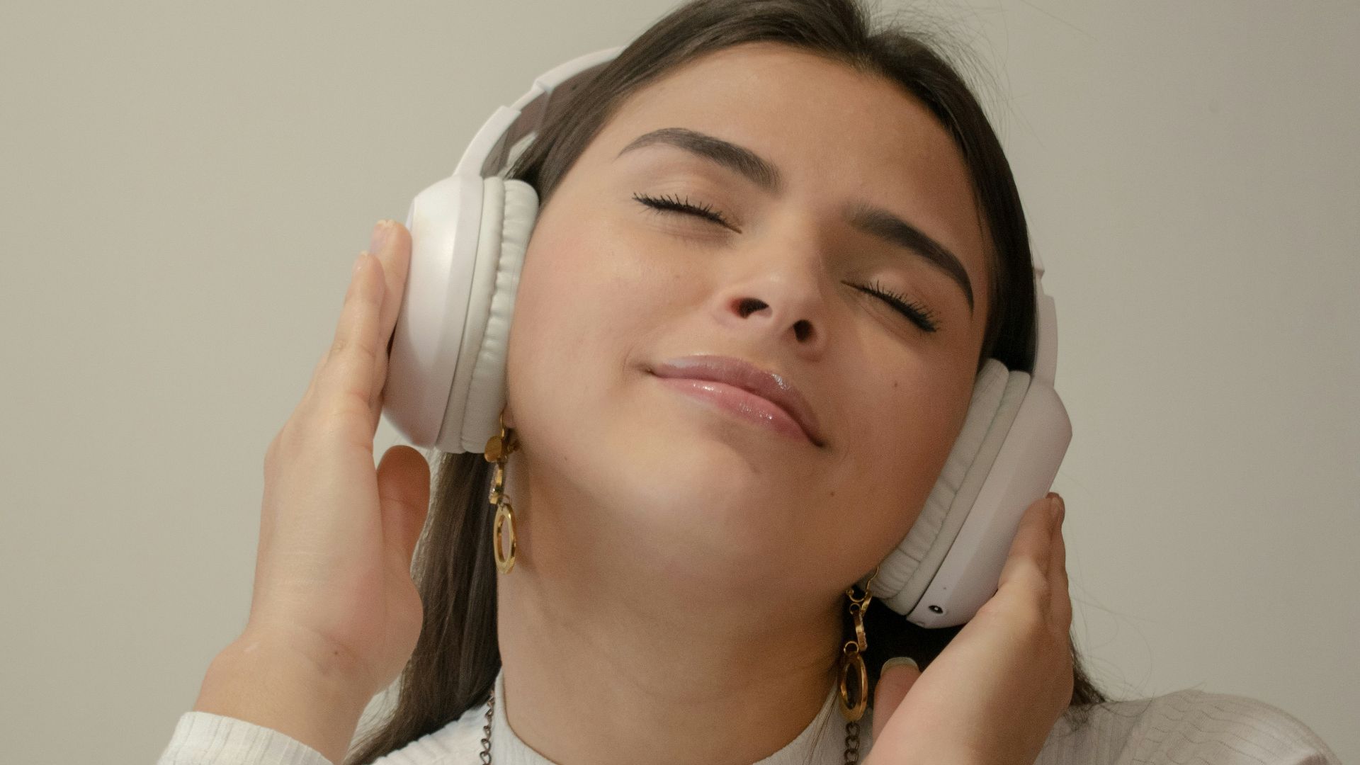 a woman with her eyes closed holding a phone to her ear