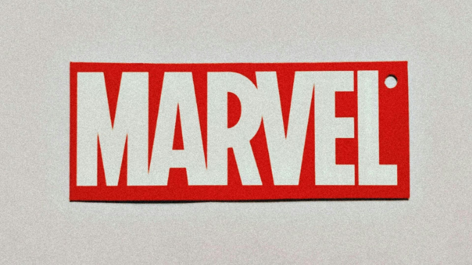 a red and white sticker with the word marvel on it
