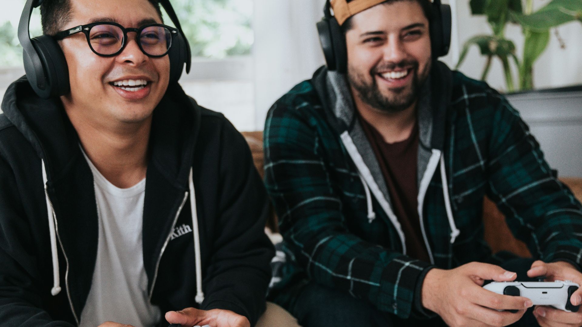 a couple of men sitting at a table with game controllers
