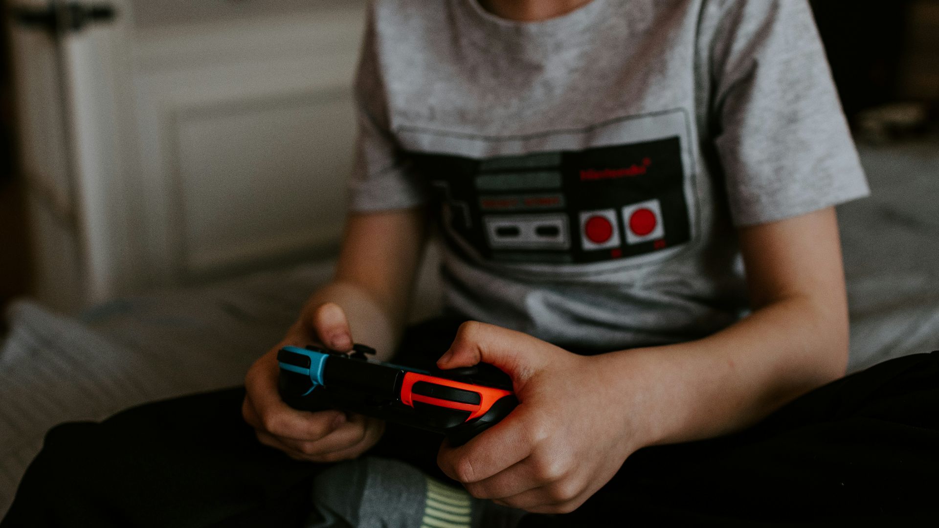 kid sitting on gray bed while playing