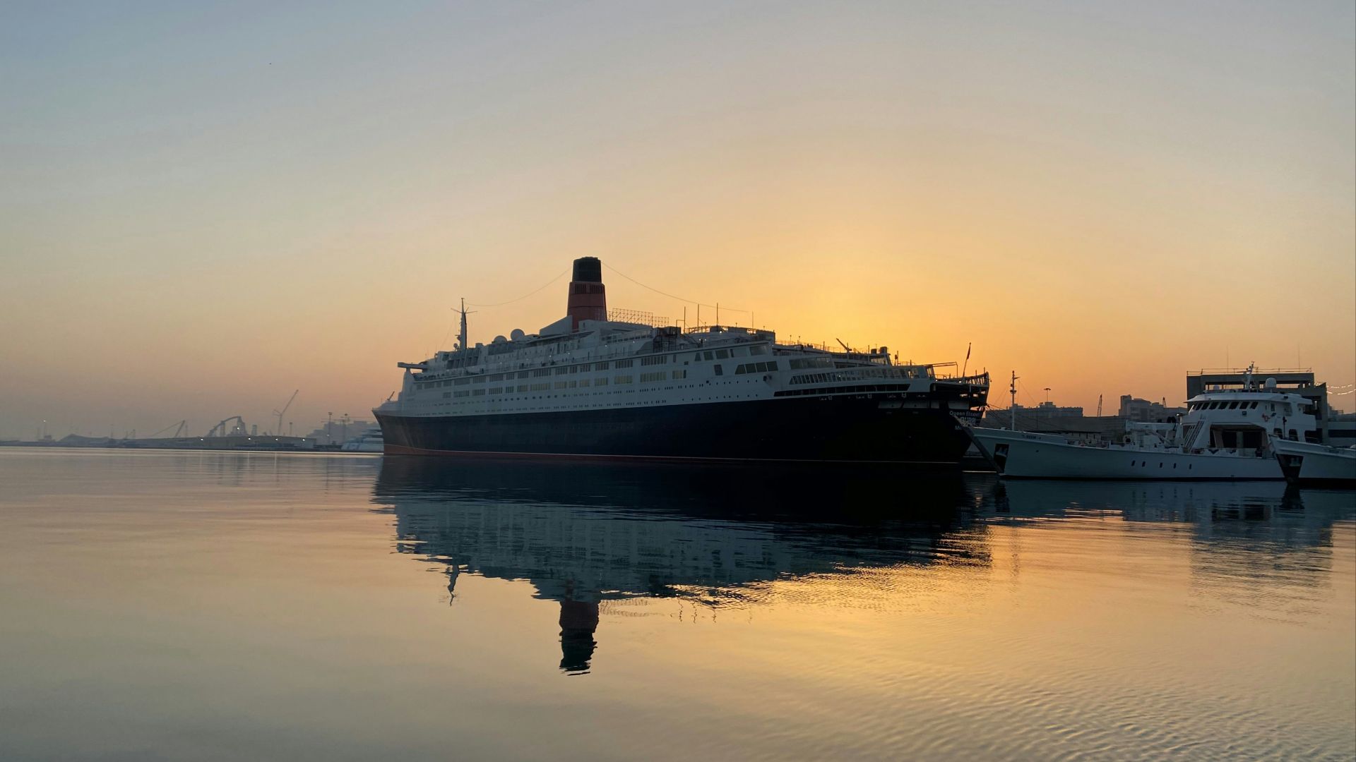 a cruise ship in the water at sunset