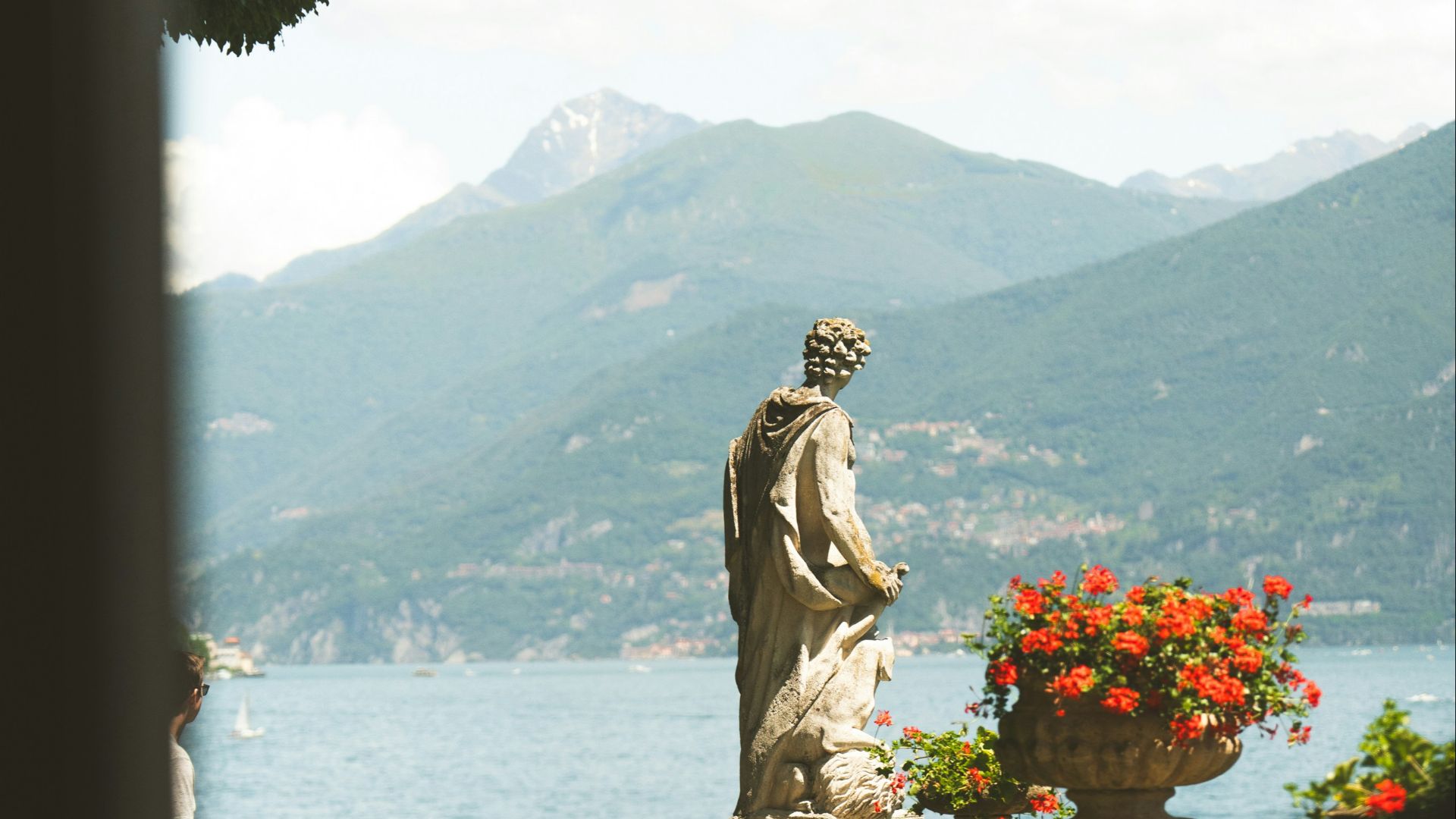 A statue sitting on top of a lush green hillside