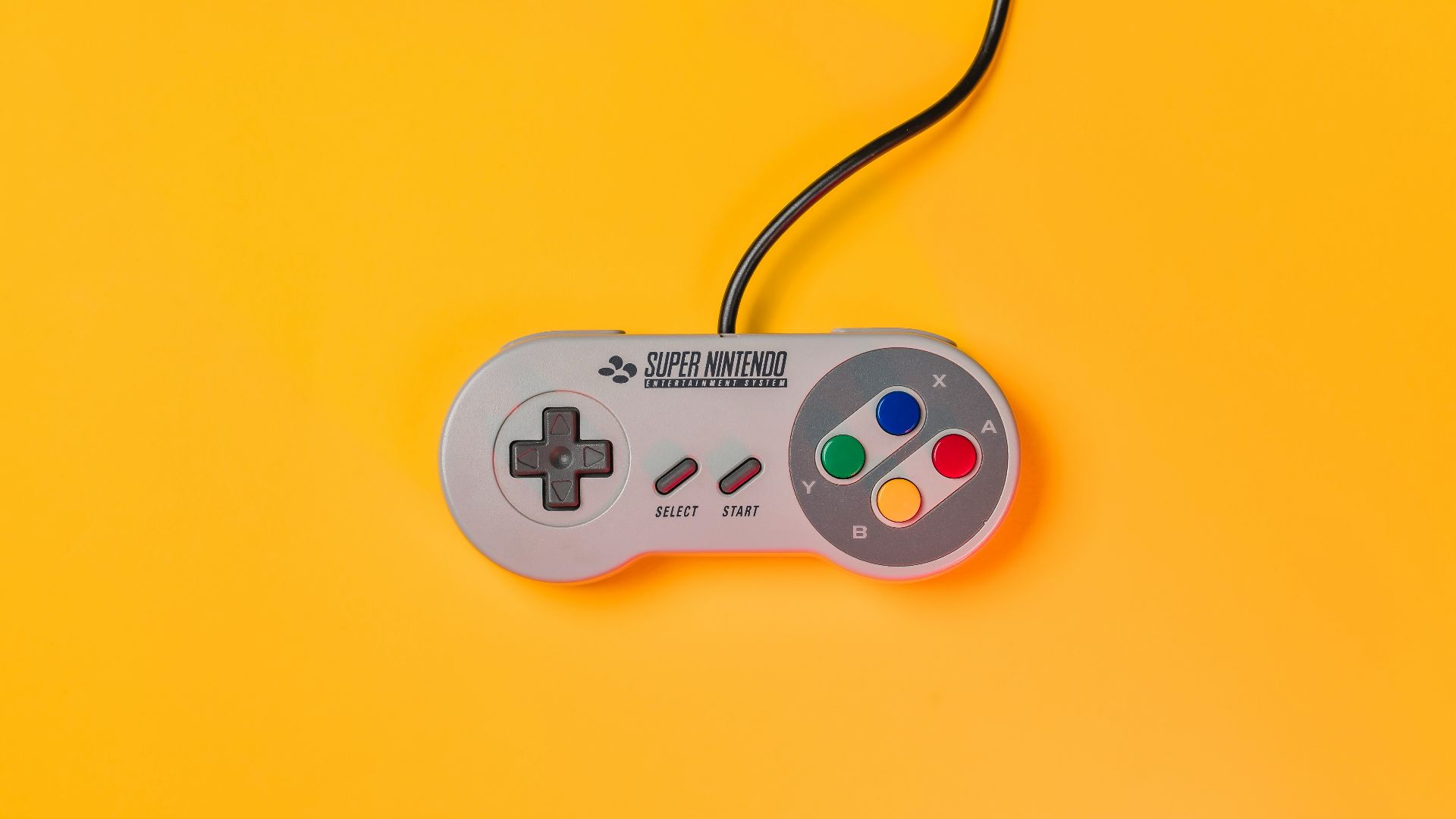 white nintendo game controller on yellow surface