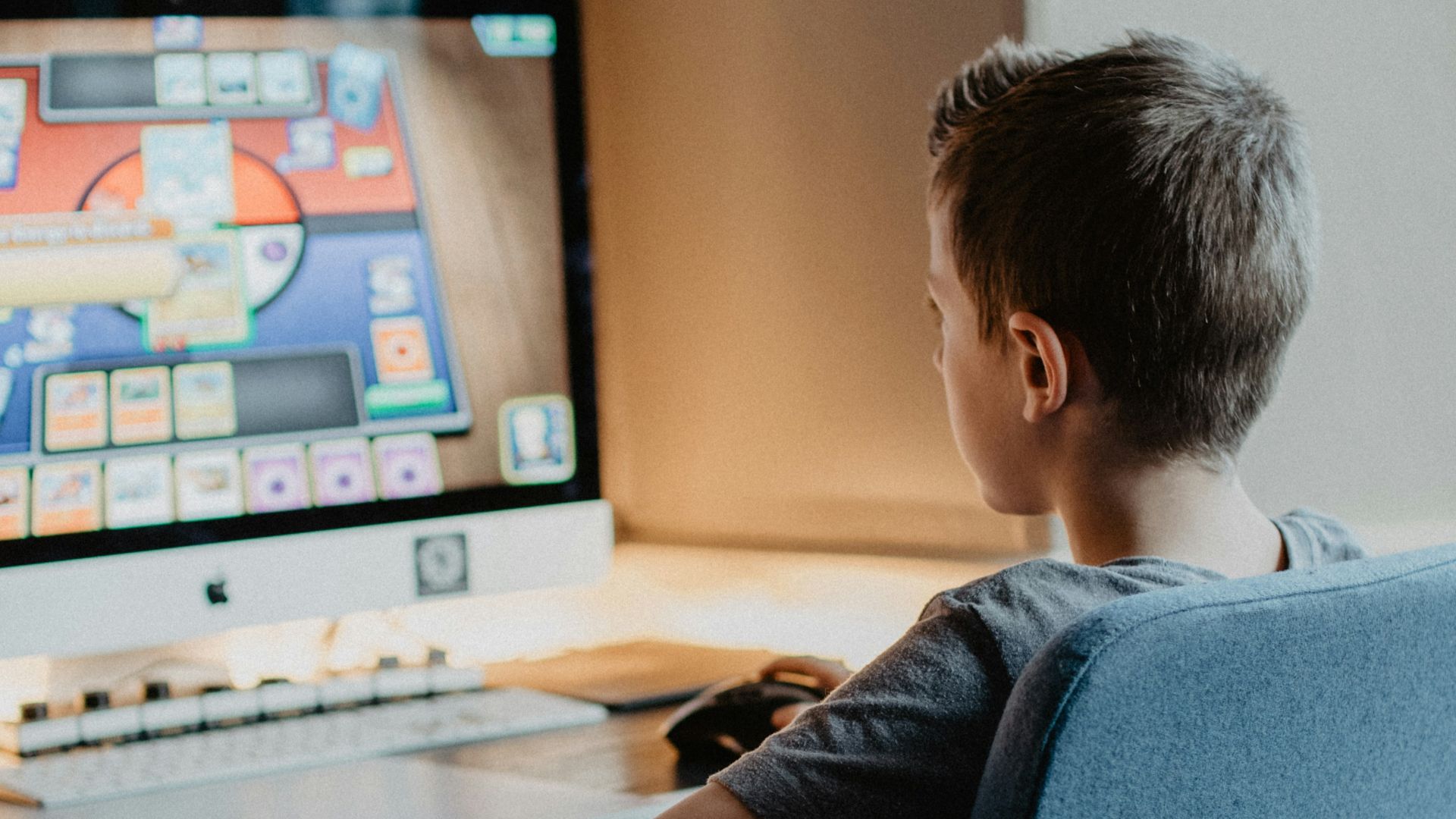 boy in black long sleeve shirt sitting on blue chair