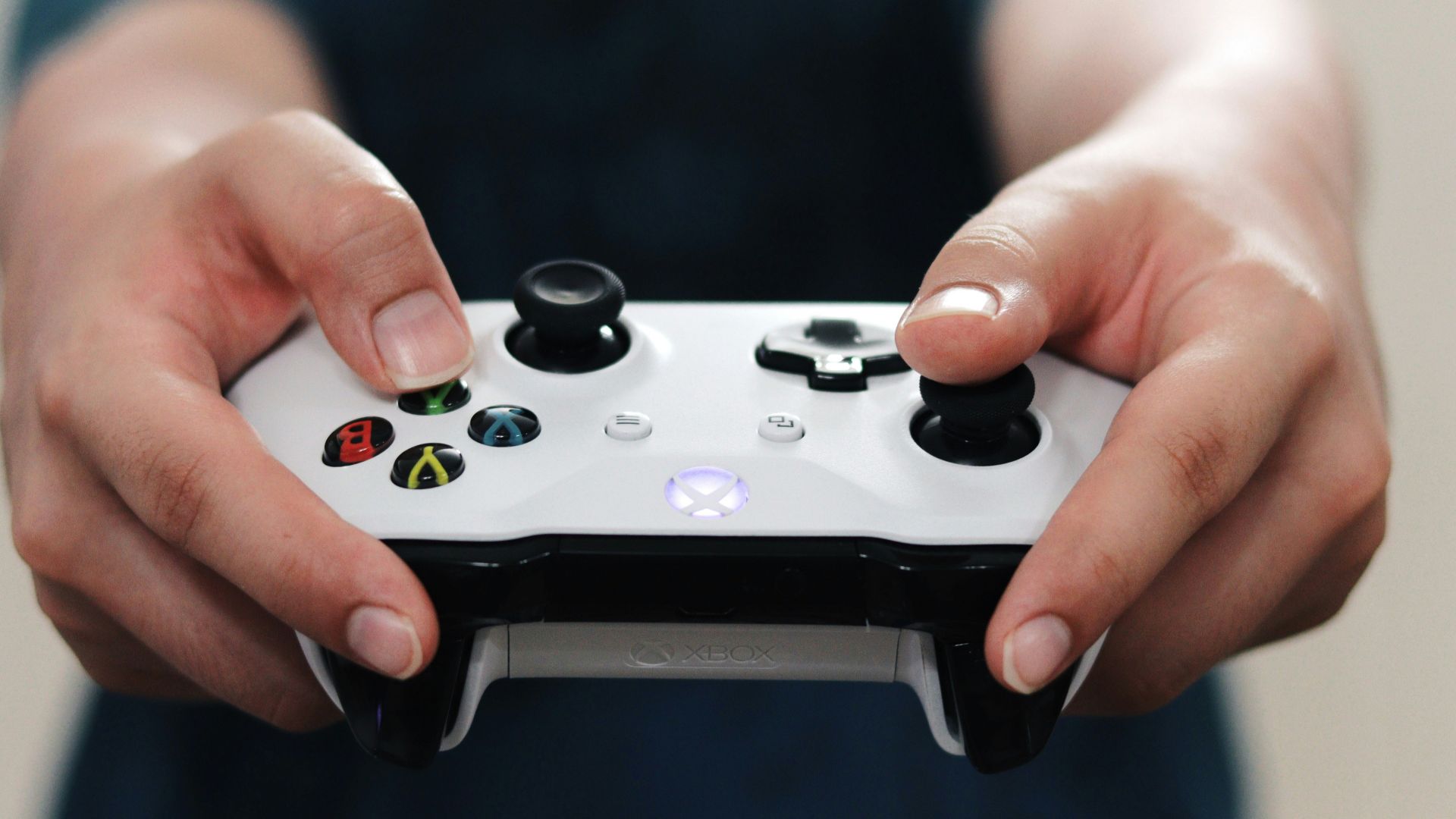 person holding white and black xbox one game controller