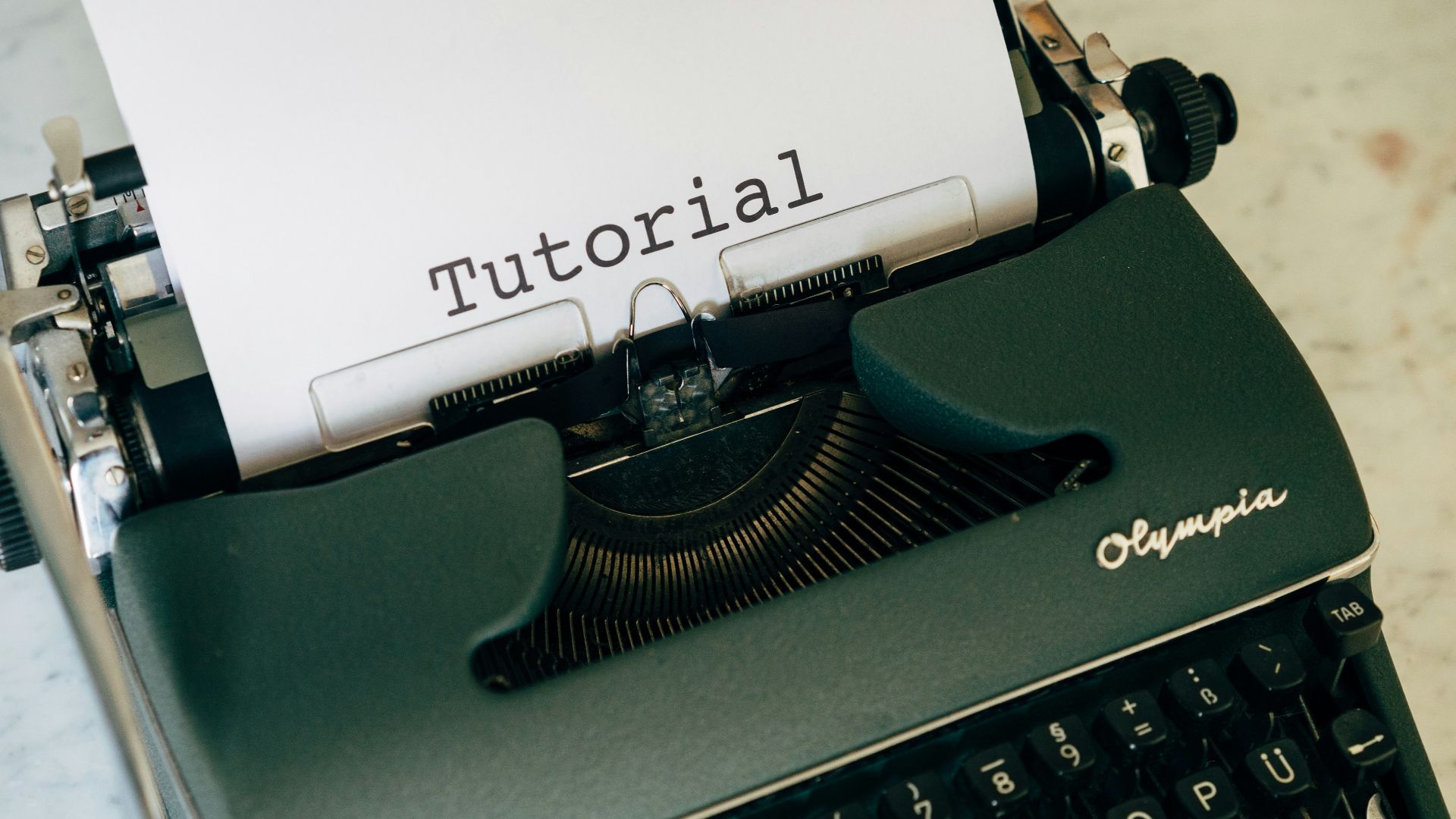 green and black typewriter with white printer paper