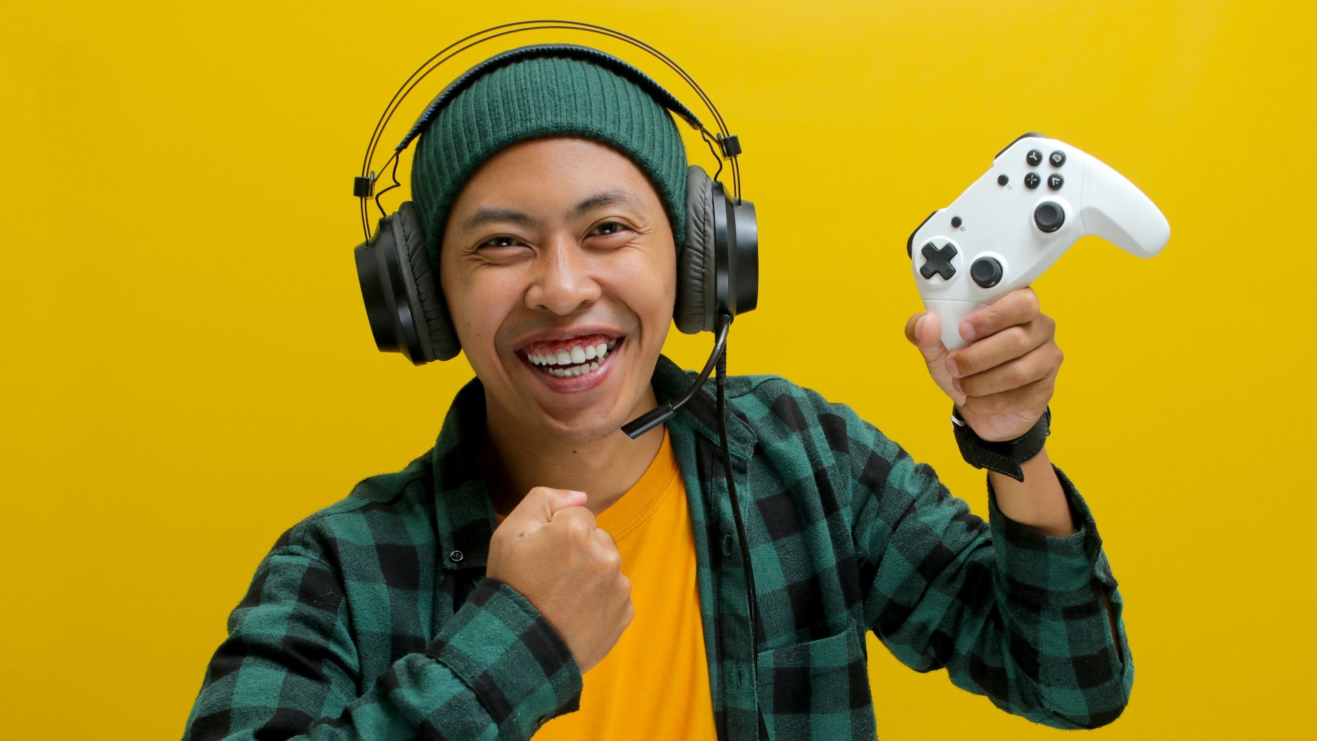 A man wearing headphones and holding a video game controller