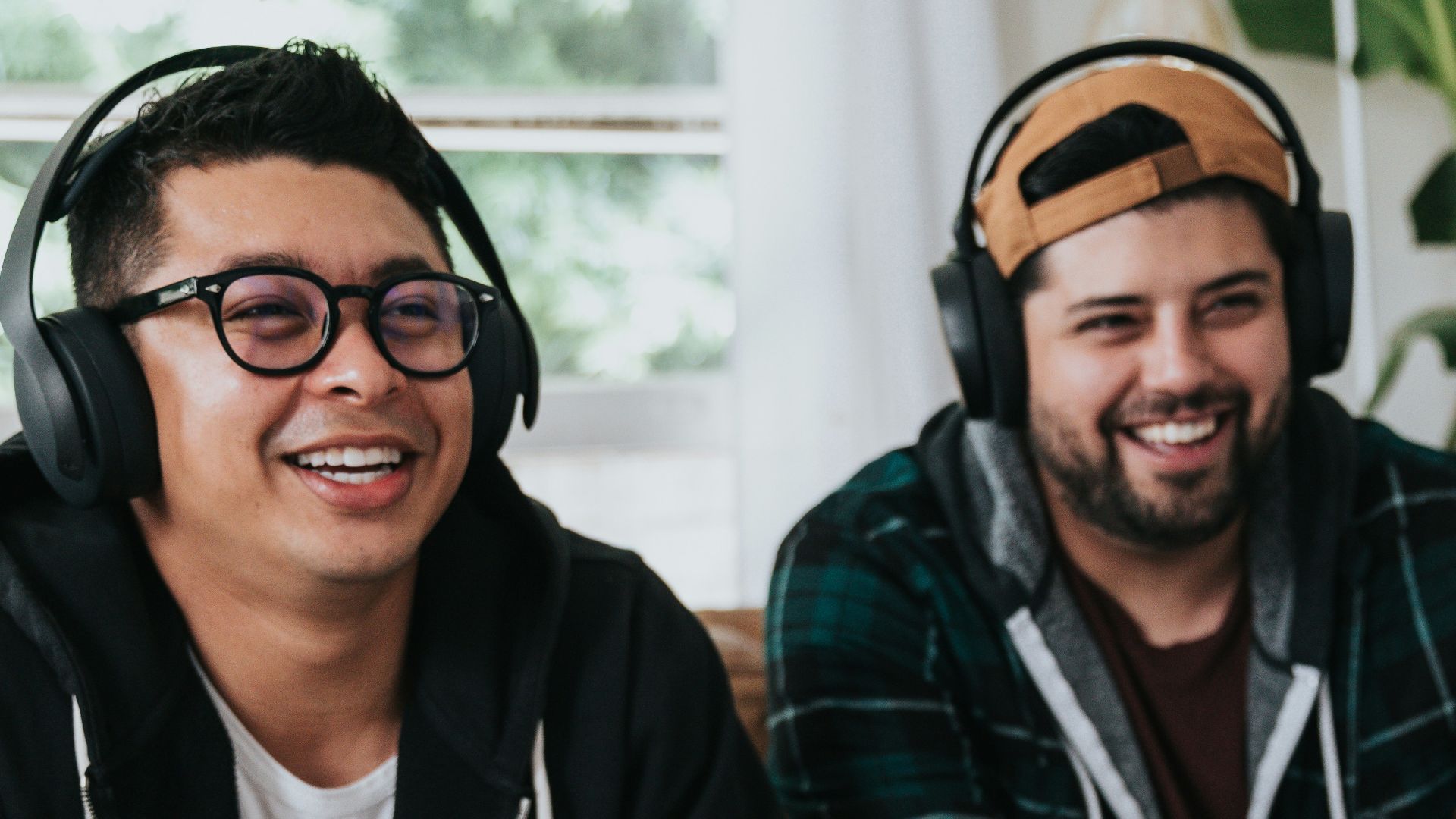 a couple of men sitting at a table with game controllers