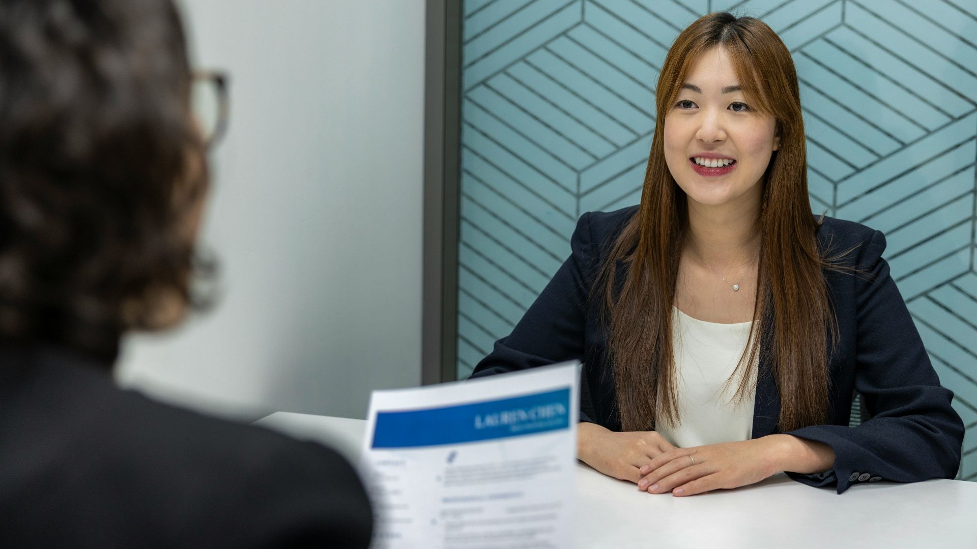 a woman sitting at a table with a piece of paper in front of her