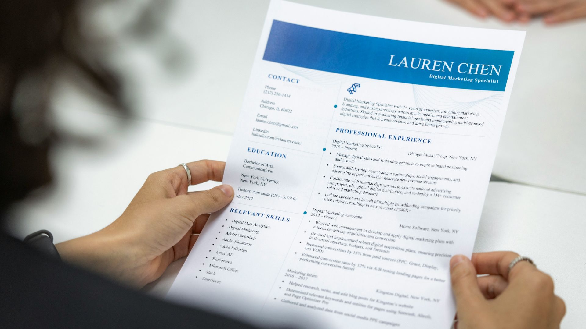 a woman is reading a resume at a table