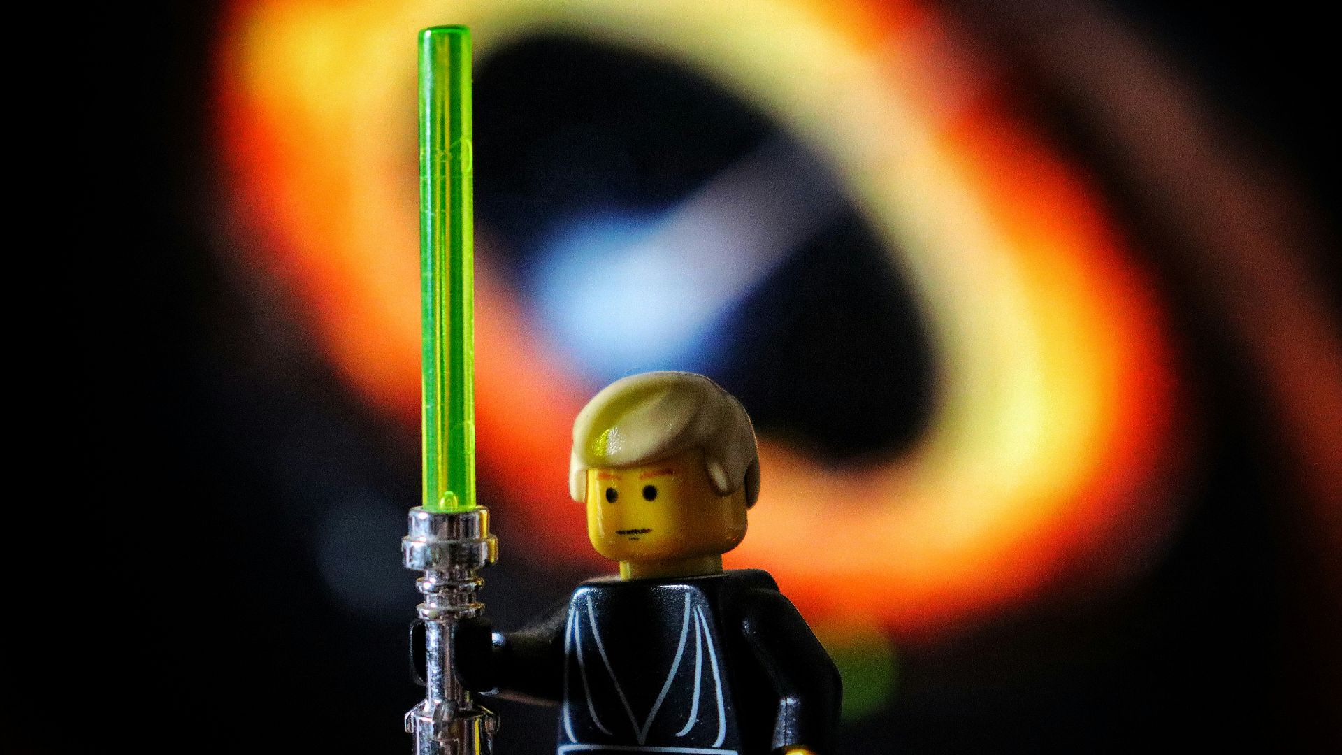 A lego figure holding a green light saber