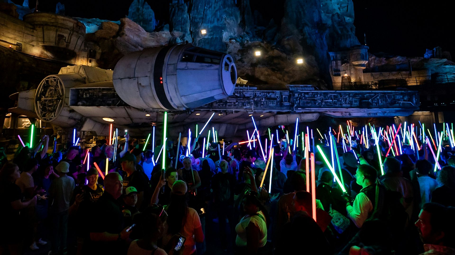 a crowd of people standing around a building with lights