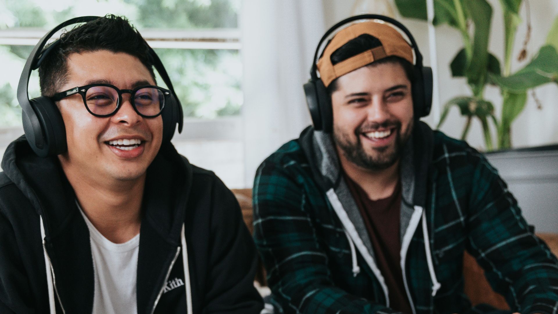 a couple of men sitting at a table with game controllers