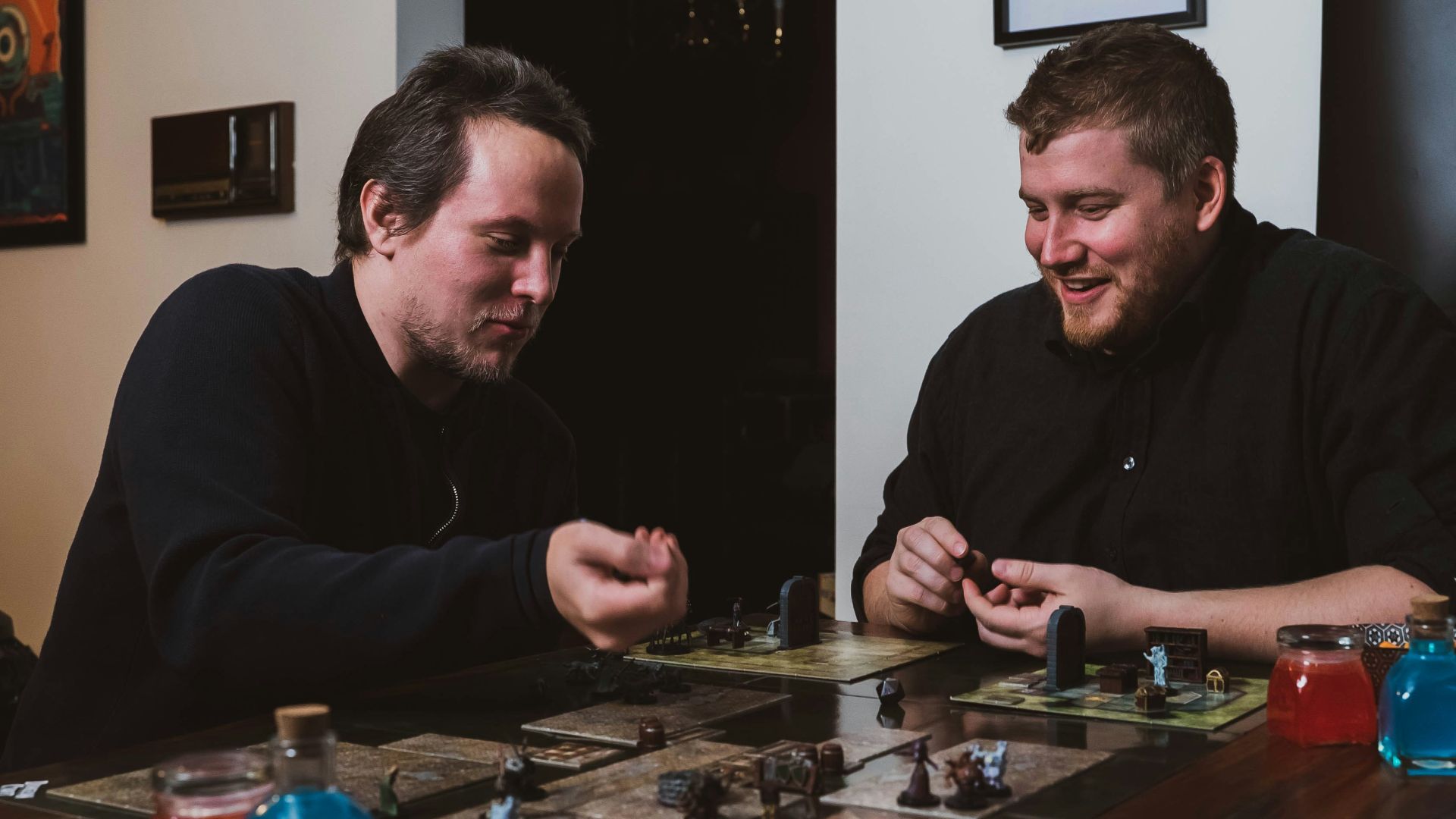 two men sitting at a table playing a board game