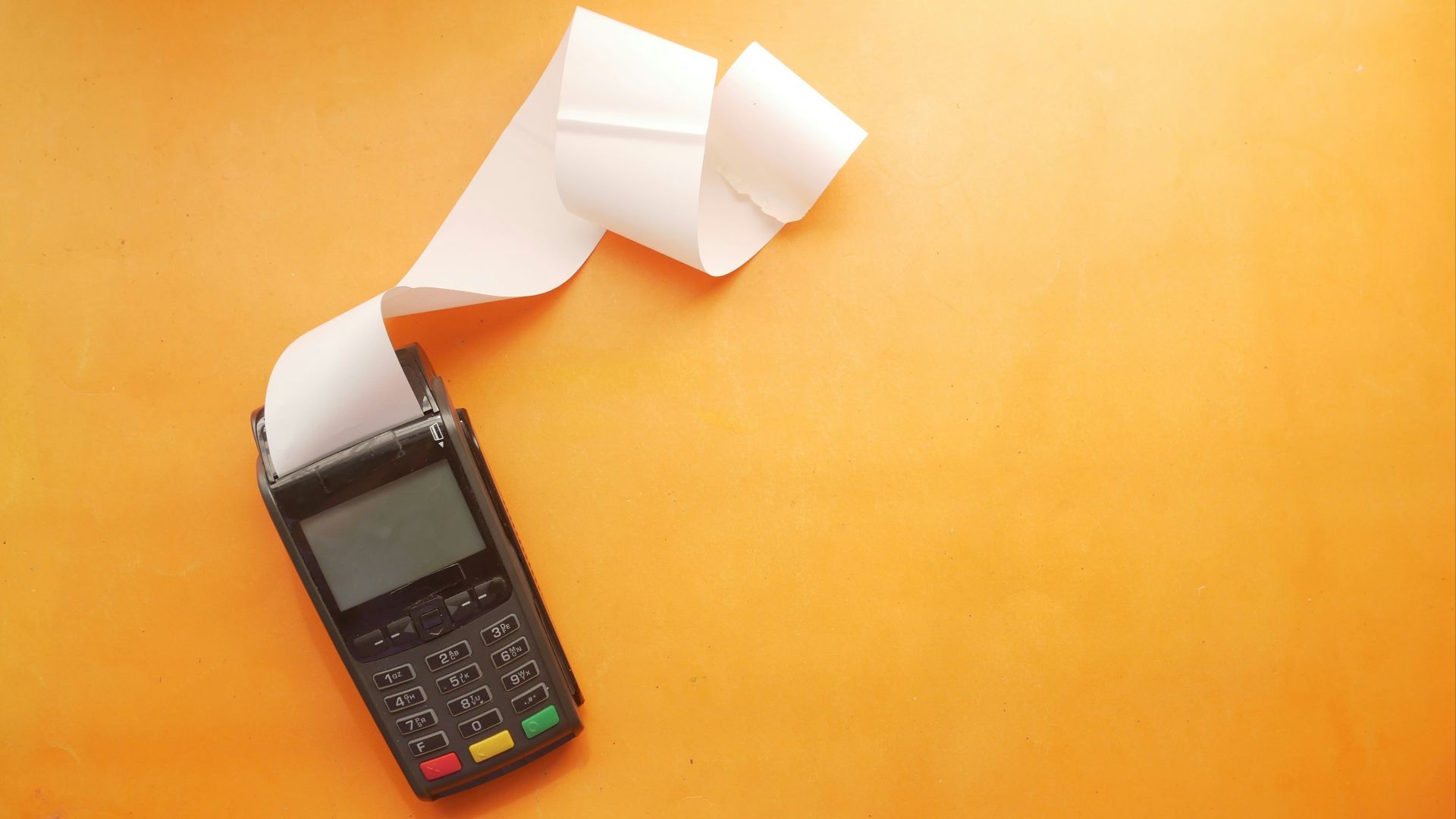 a cell phone sitting on top of a table next to a roll of paper
