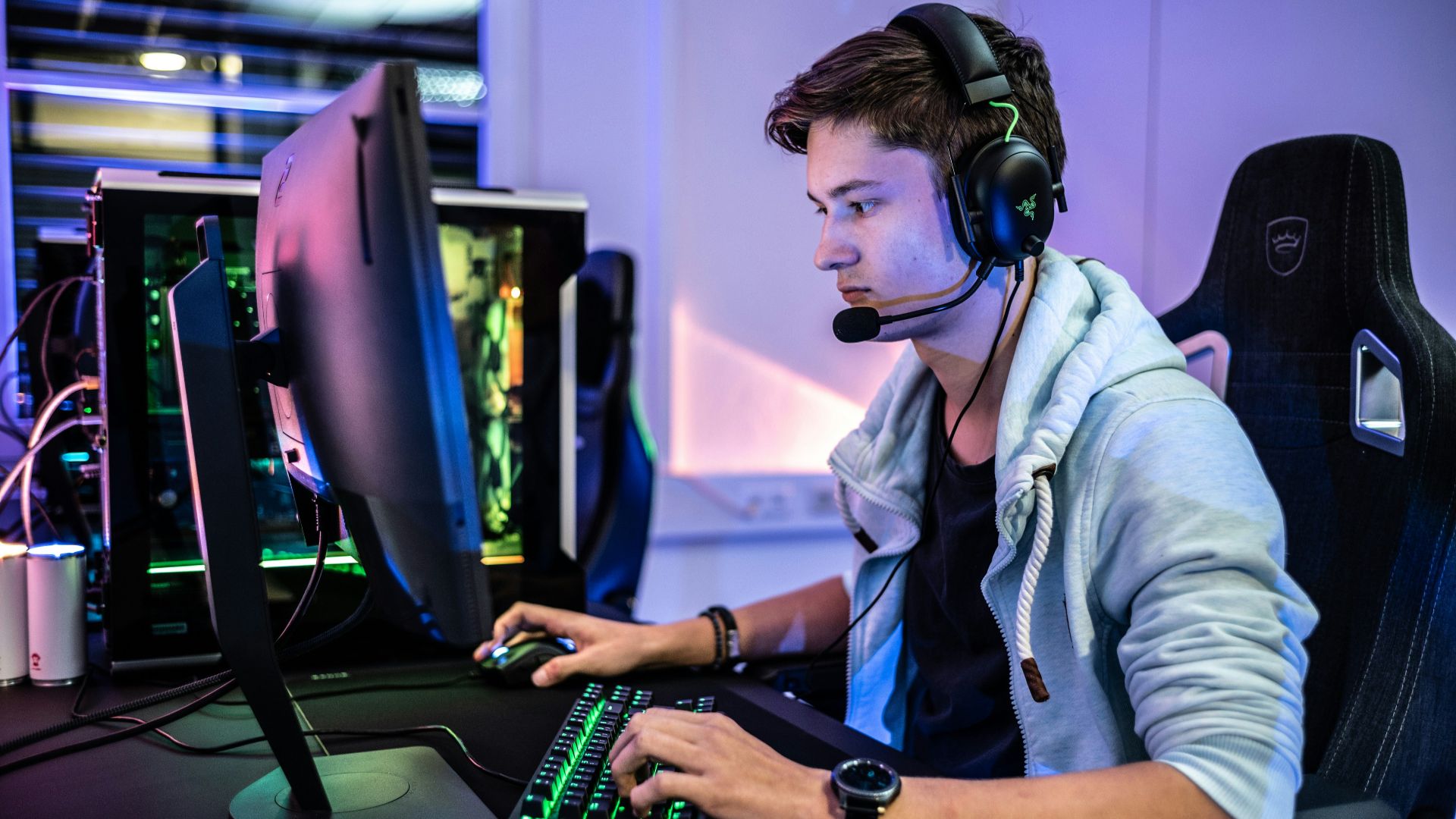 a man wearing a headset sitting in front of a computer