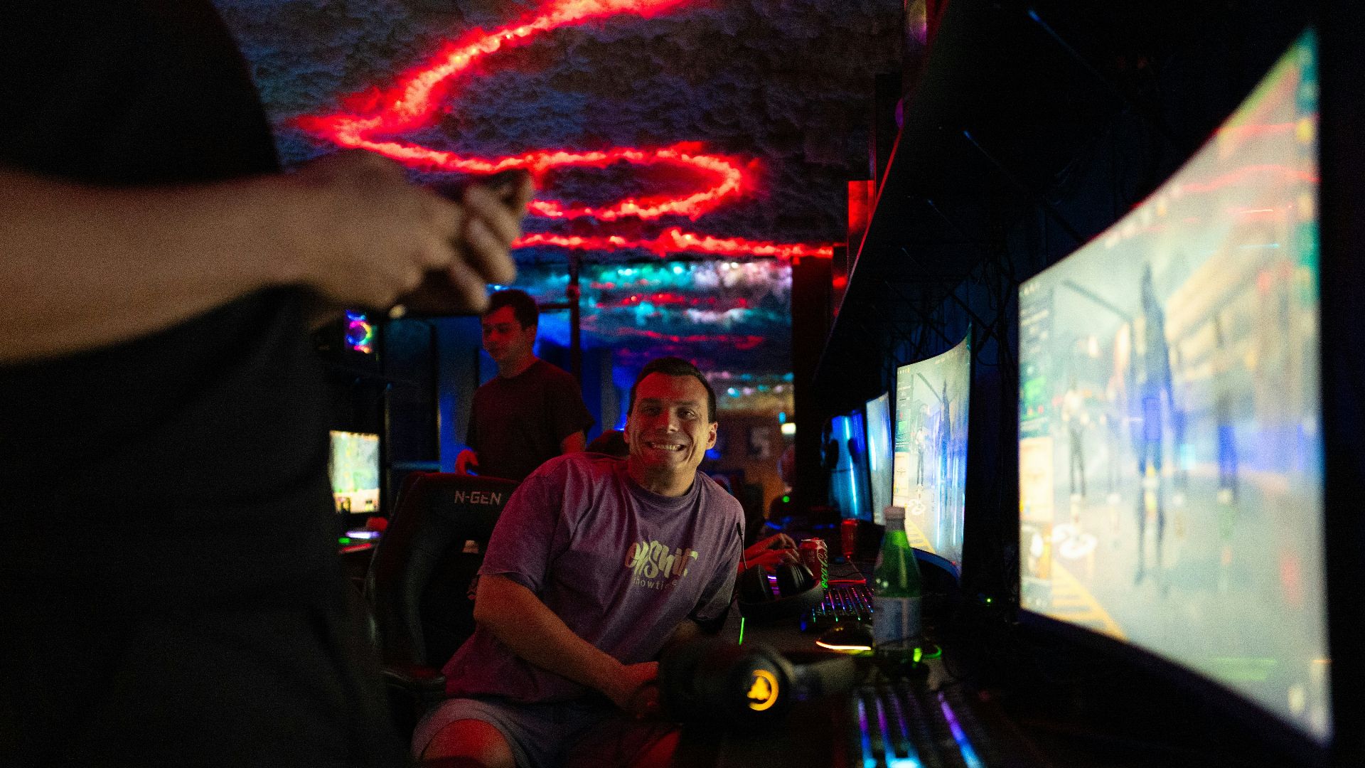 People playing video games in a dimly lit room.