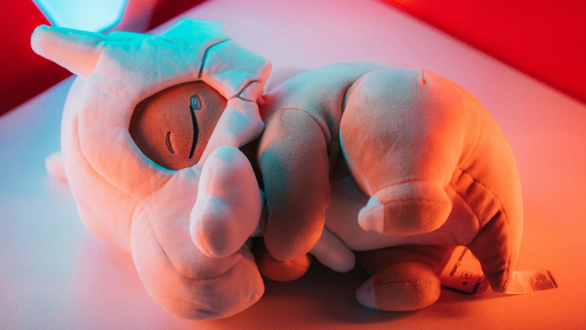 a stuffed animal laying on top of a white table