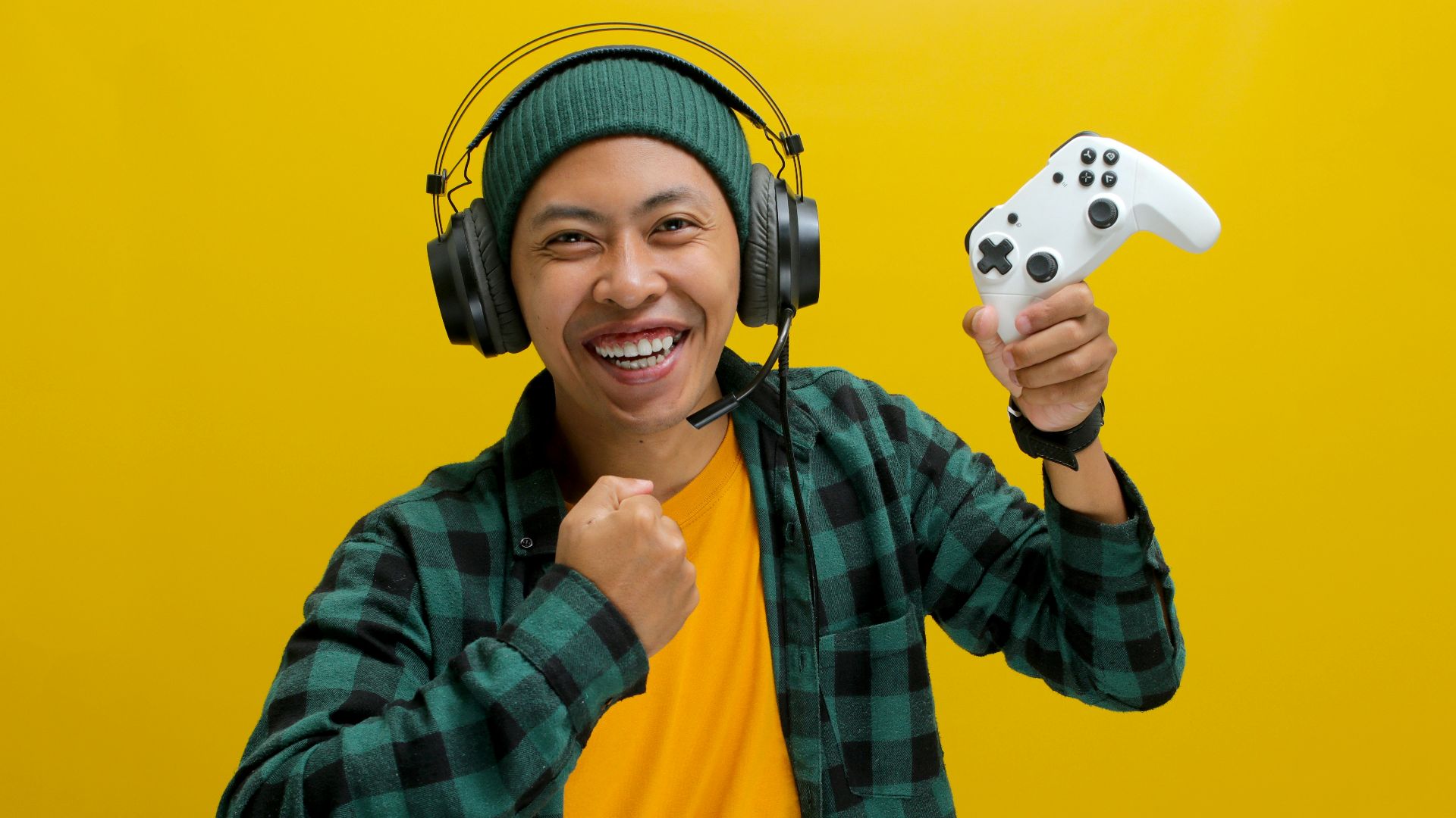 A man wearing headphones and holding a video game controller