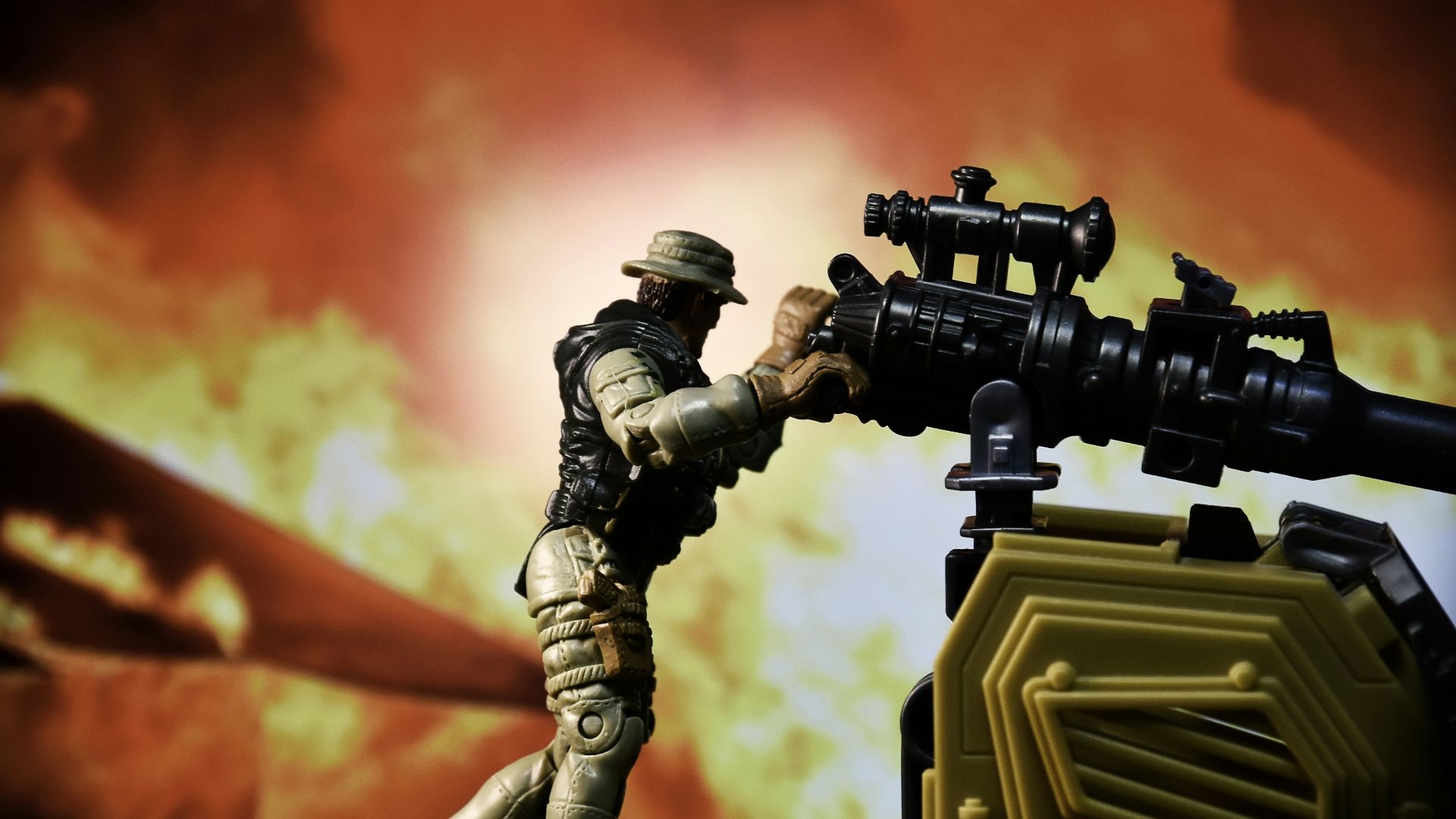 a toy soldier with a machine gun in front of a fire